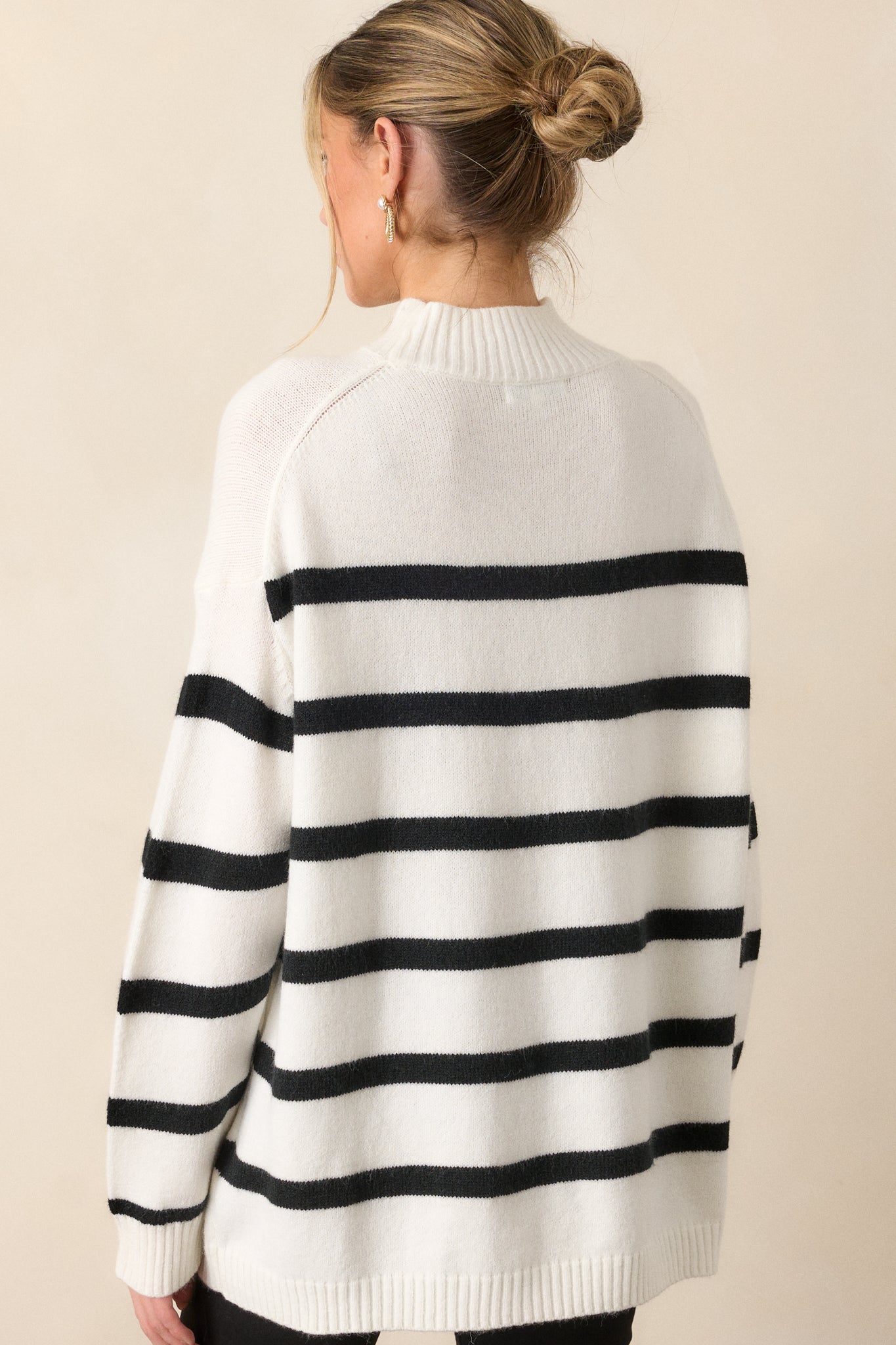 Back view of the sweater, showing the continuation of the black horizontal stripes and oversized fit across the back.