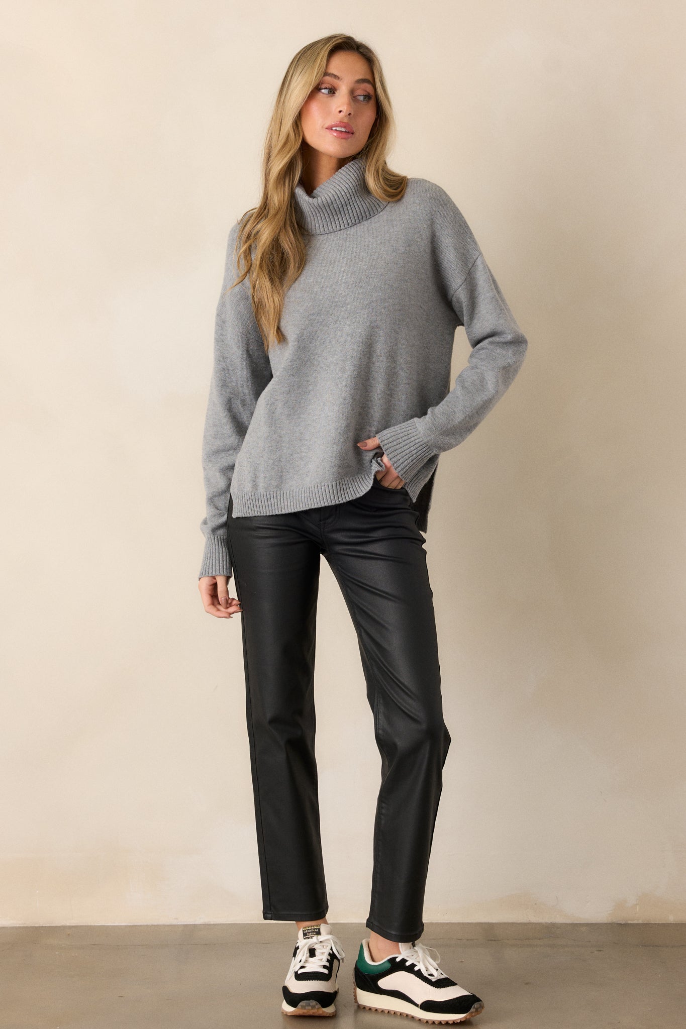 Grey knit, long sleeve sweater with ribbed cuffs and a ribbed turtleneck. 