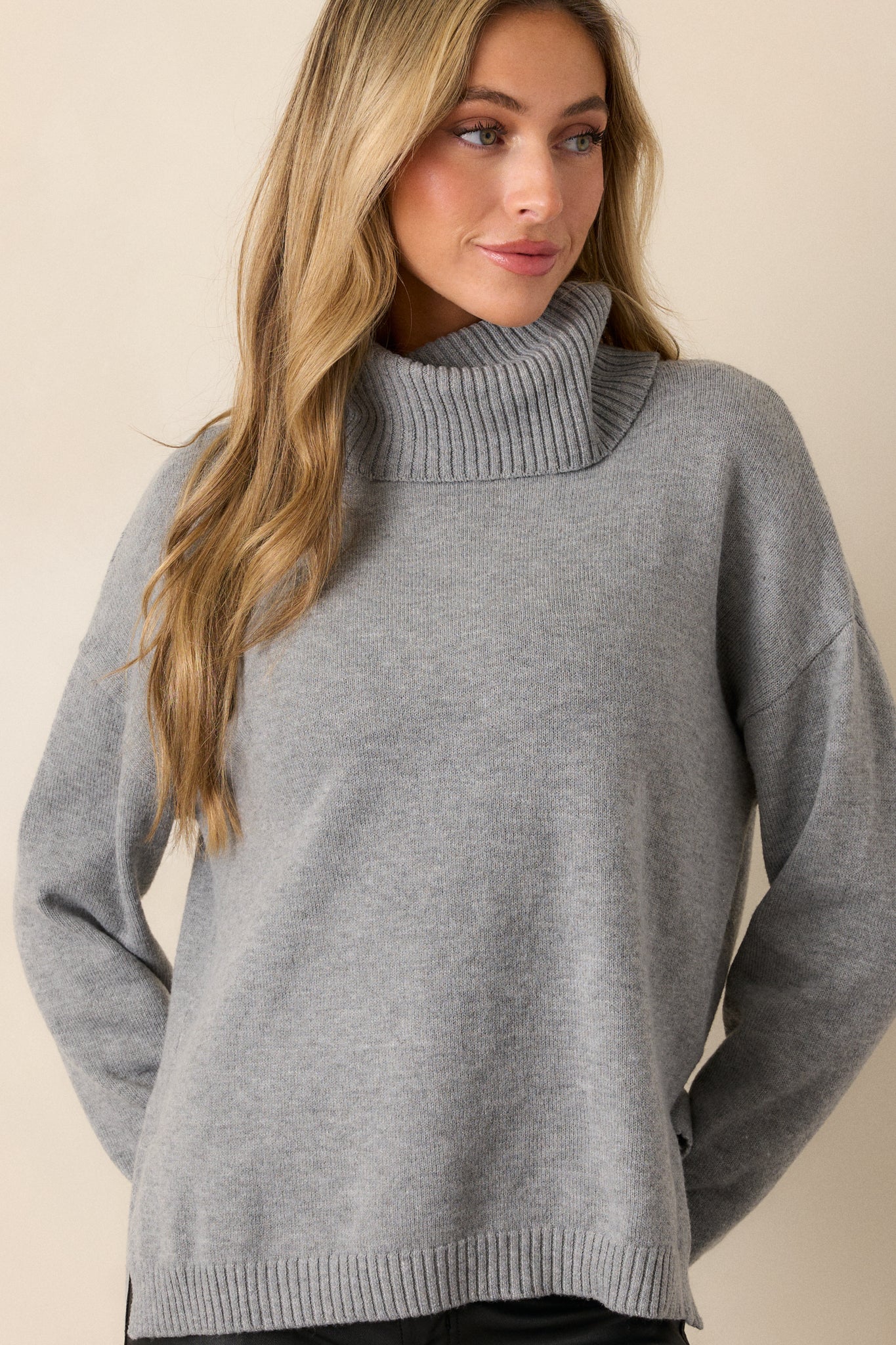 Front view of a grey sweater featuring a chunky cowl neckline accompanied by ribbed detailing, straight long sleeves completed by ribbed cuffs, and a straight hemline.