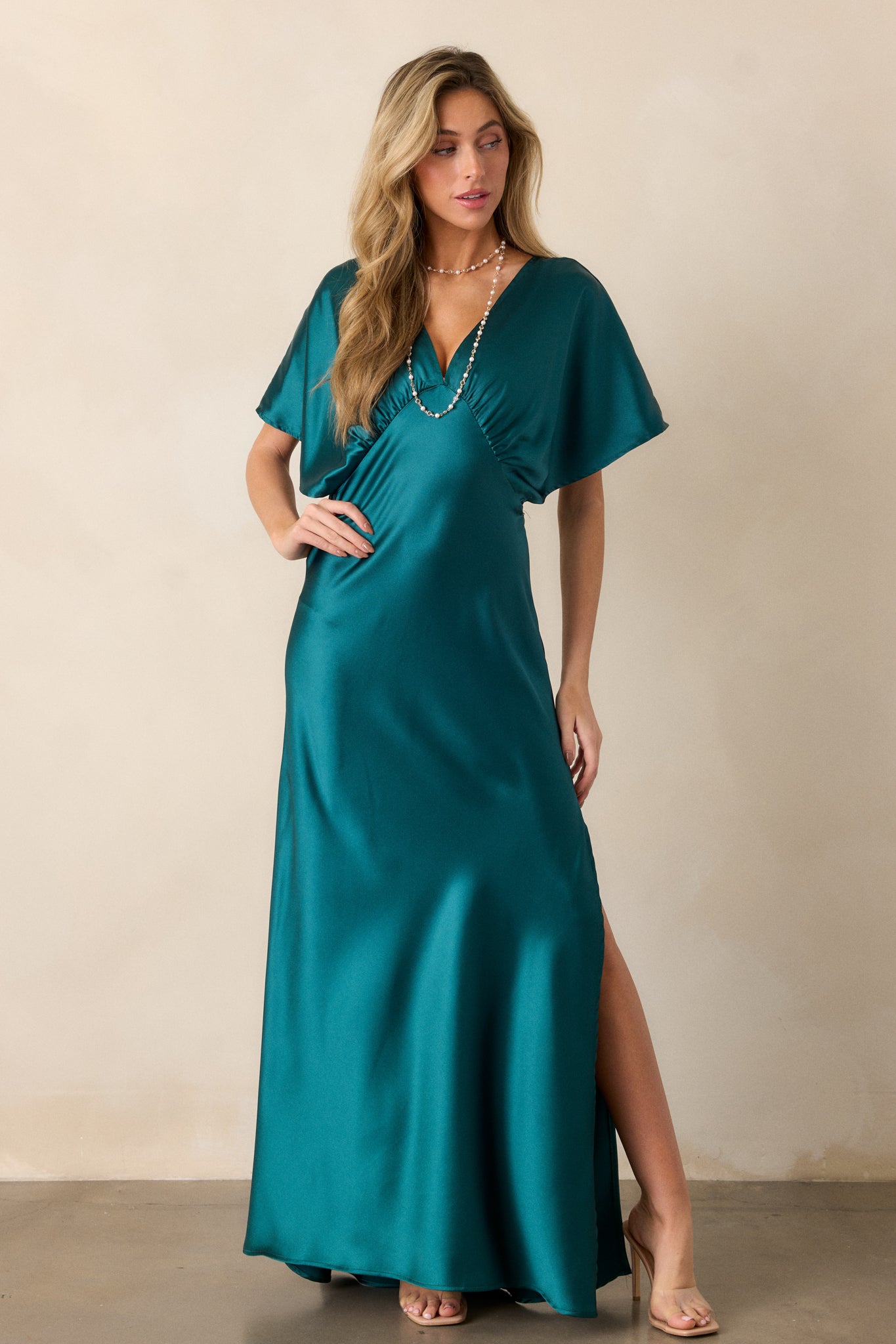 Full-body shot of the teal satin dress highlighting the side slit and flowing kimono-style sleeves.