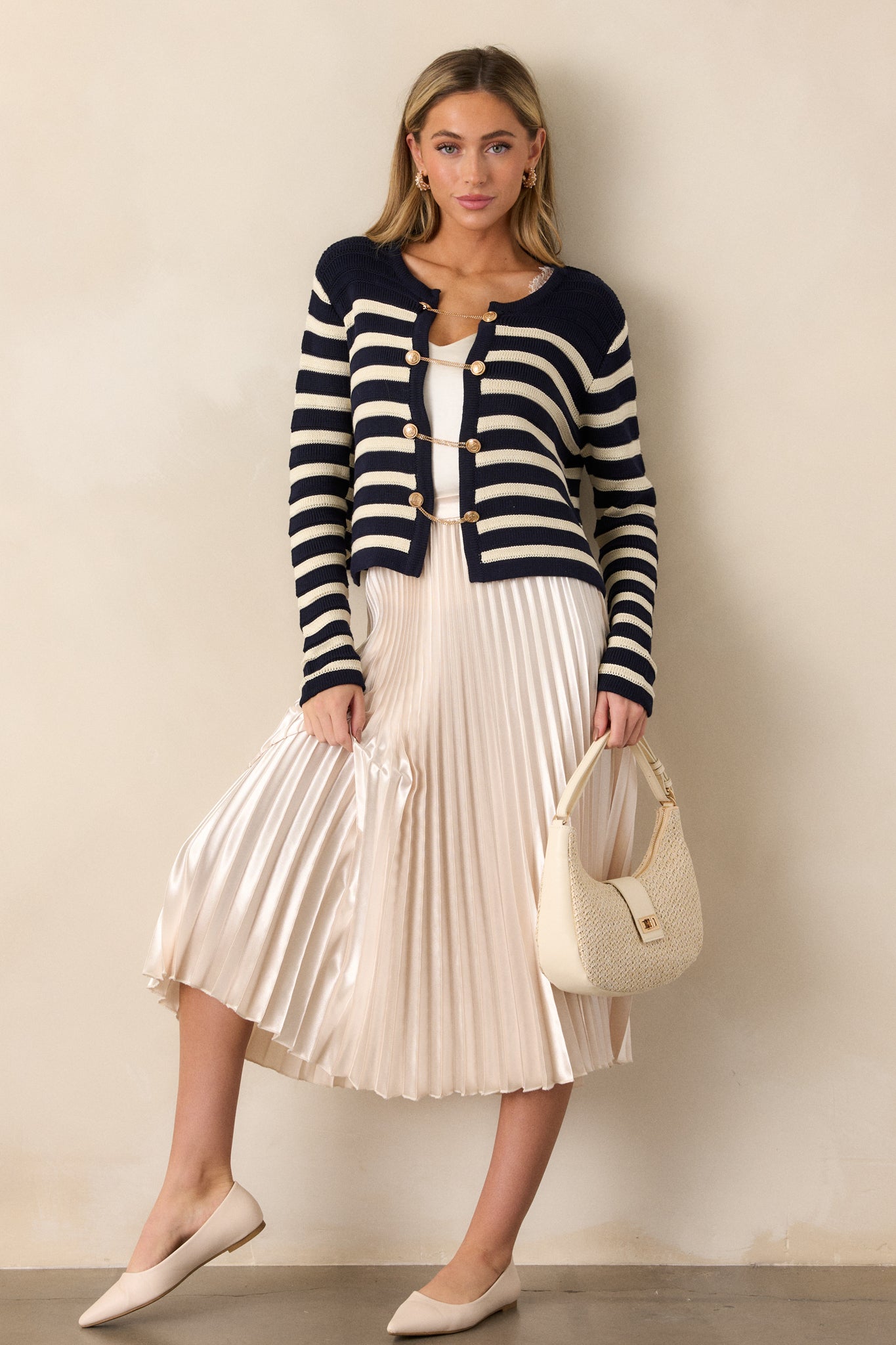 A full length view of the cardigan, highlighting the long sleeves and stripe pattern across the body and sleeves.