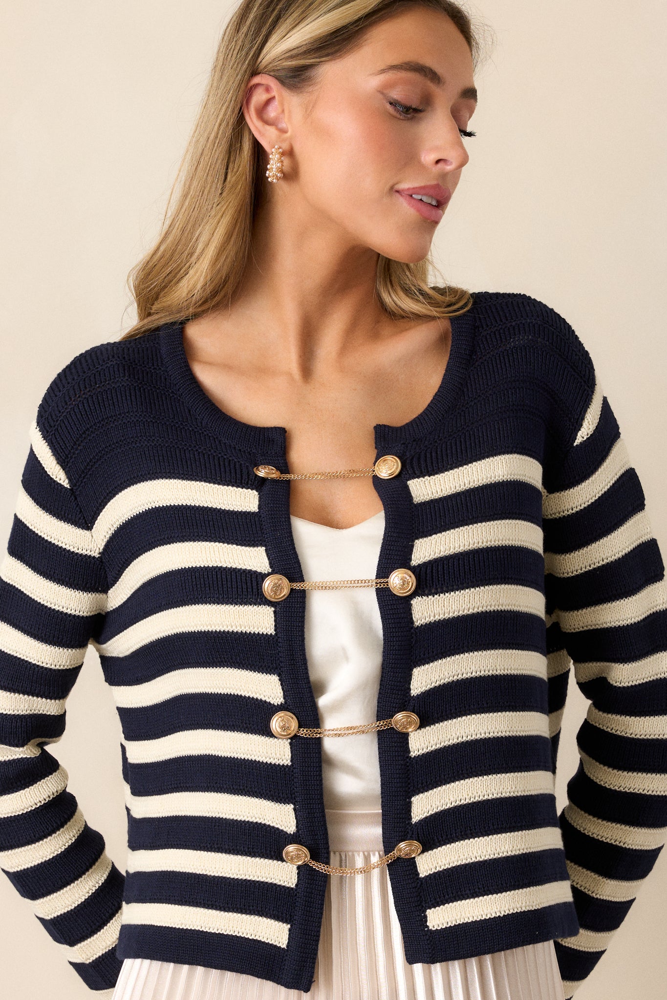 Close-up of the front buttons, showcasing the gold button and chain detailing on the navy and white stripe pattern.