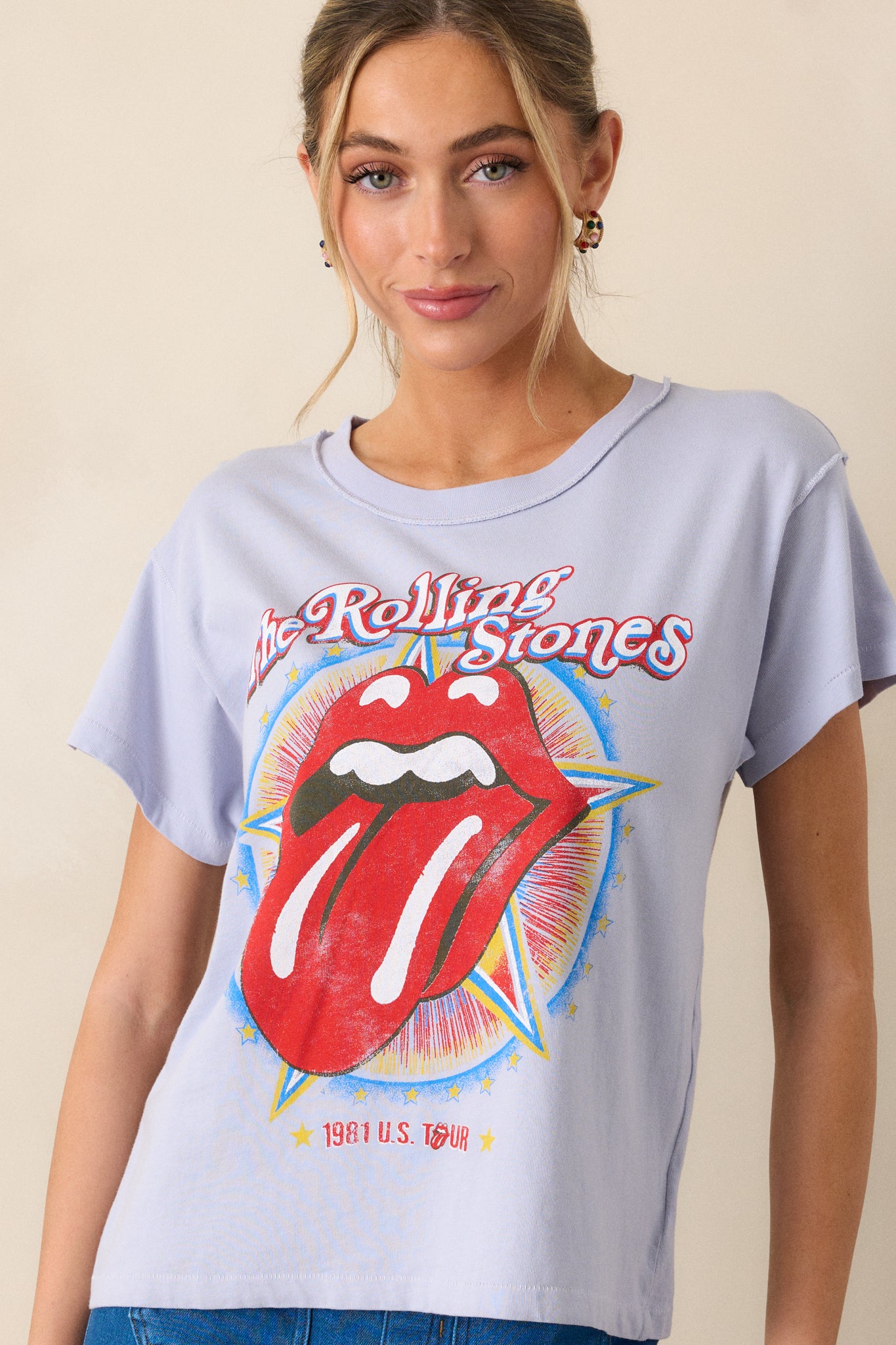 A cropped view showcasing the short sleeves and a portion of the graphic, detailing the vintage "Rolling Stones 1981" print on the lavender top with subtle details of the fabric.