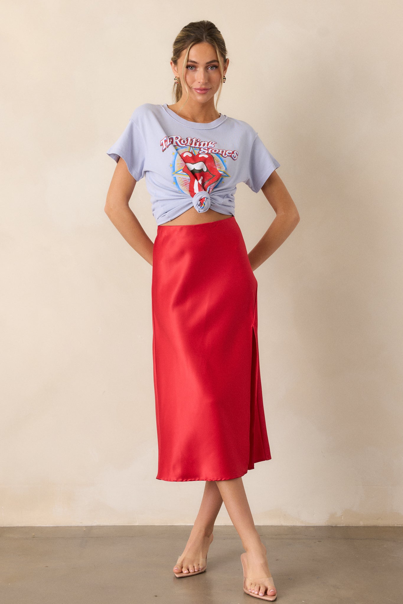 A full-length view of the lavender top with a round neckline and short sleeves. The "Rolling Stones 1981" graphic is visible on the front, showcasing the relaxed fit and vintage rock aesthetic of the shirt.