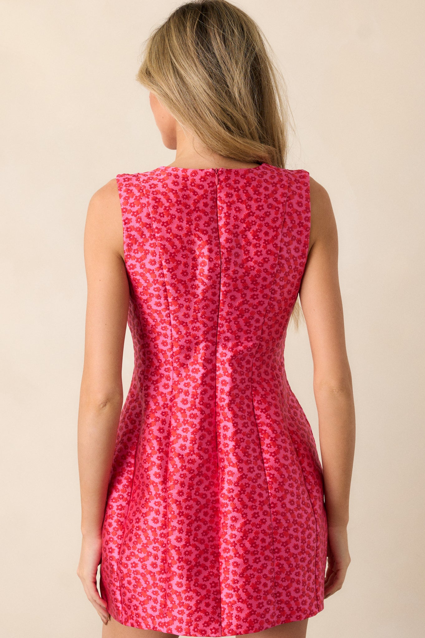 Back view of the pink mini dress featuring a discrete zipper and structured fit.