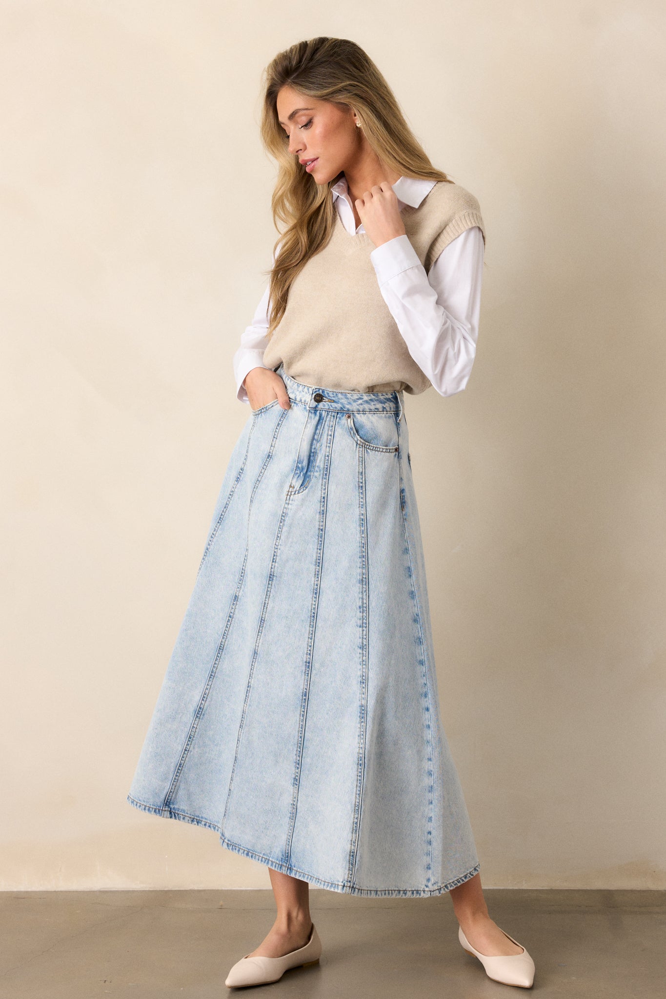 A full-length view of the light wash denim skirt, showcasing its high-waisted design and how it falls to lower-calf, highlighting its relaxed fit.