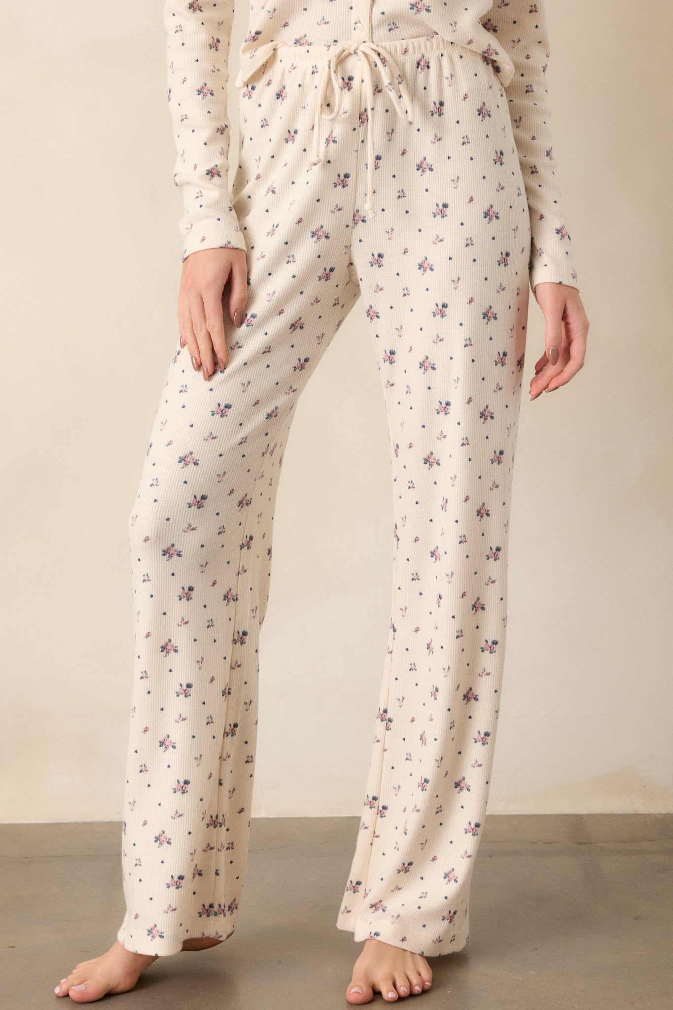 Cropped view of the lower portion of the pants, capturing the ditsy rosebud print and the straight leg cut detail.