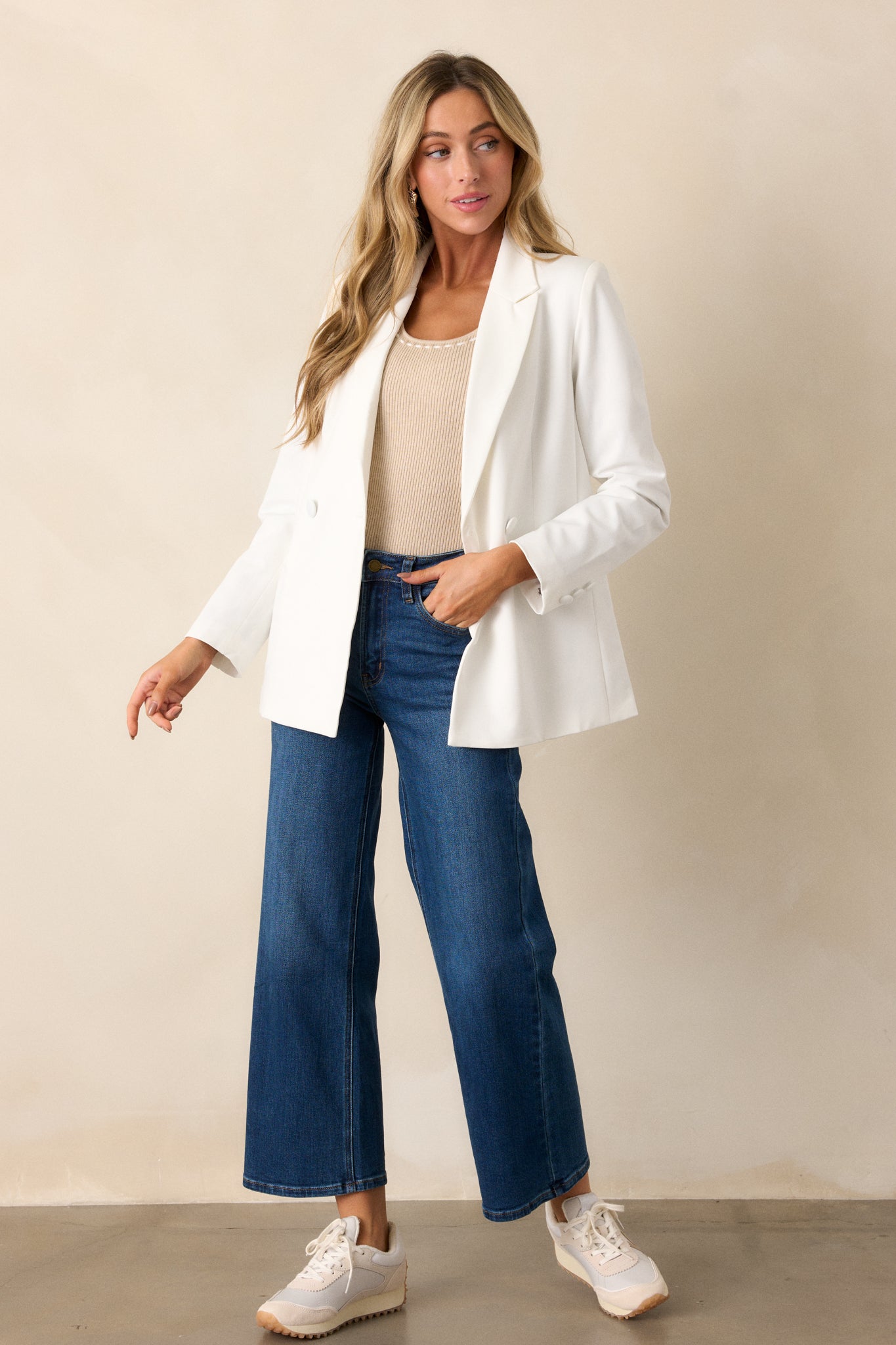 This white blazer features two functional pockets, functional buttons, a lapel collar, lightweight shoulder pads, and a multicolor print lining.