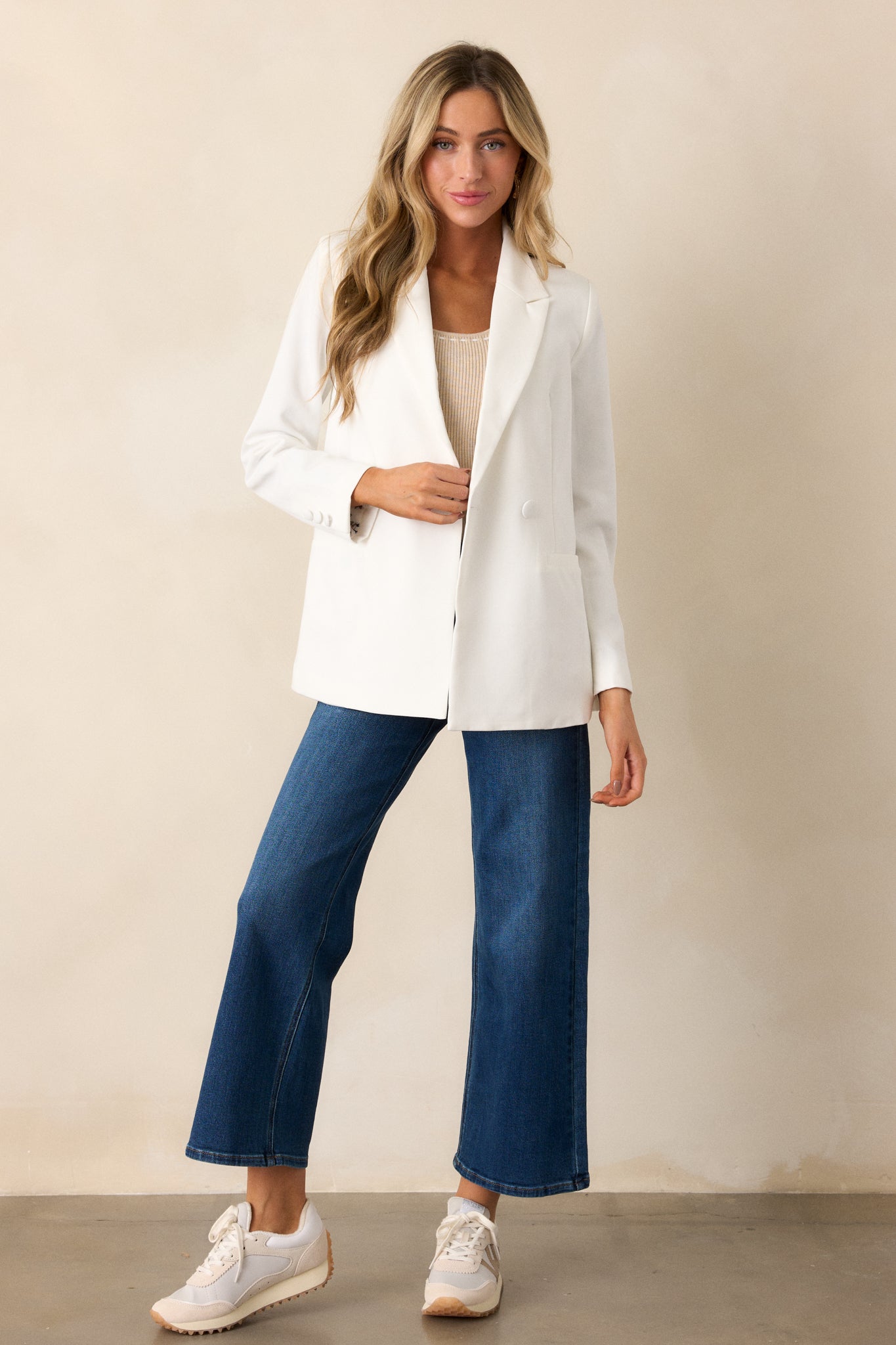 Full body view of this white blazer that features two functional pockets, functional buttons, a lapel collar, lightweight shoulder pads, and a multicolor print lining.