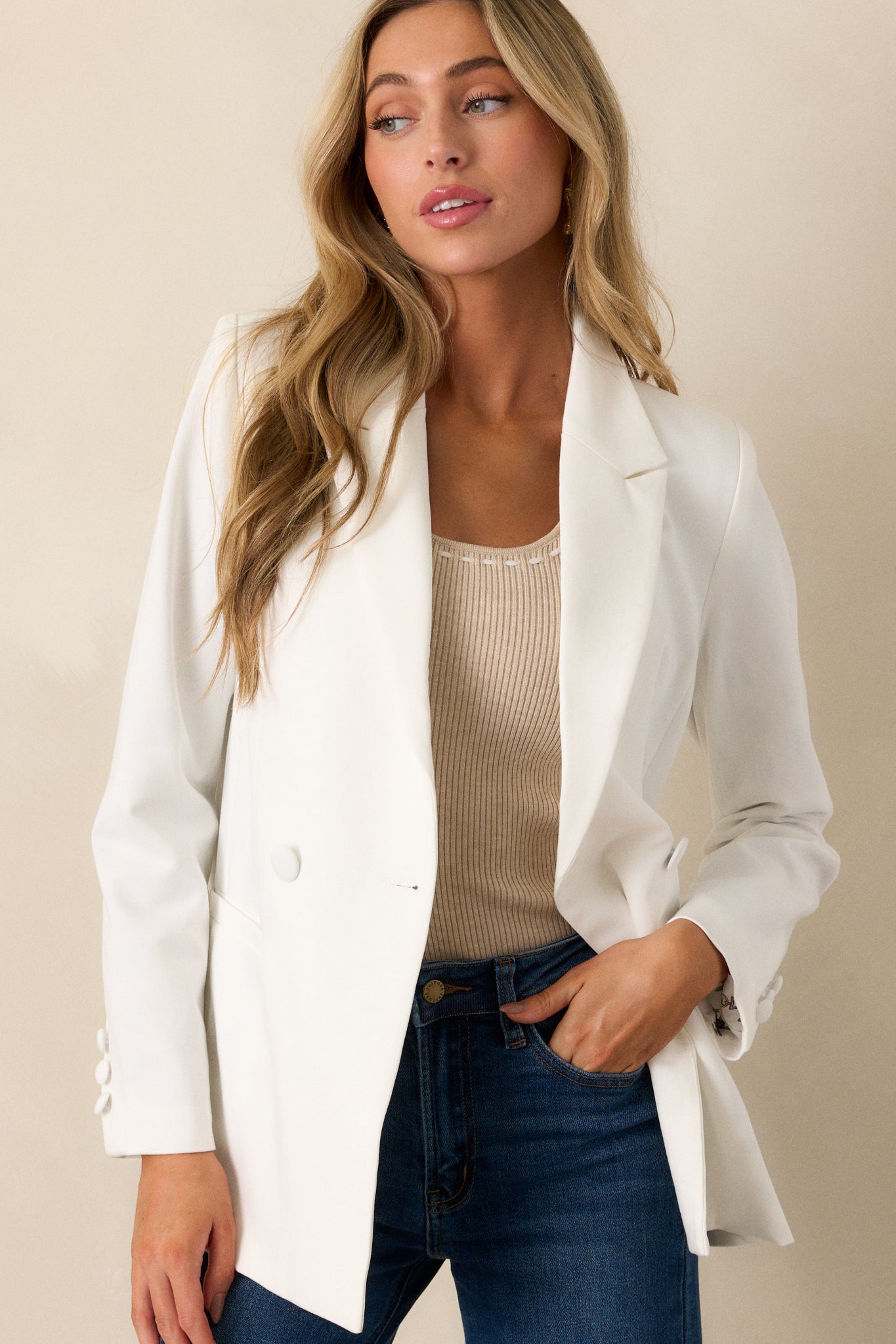 Front view of this white blazer that features two functional pockets, functional buttons, a lapel collar, lightweight shoulder pads, and a multicolor print lining.