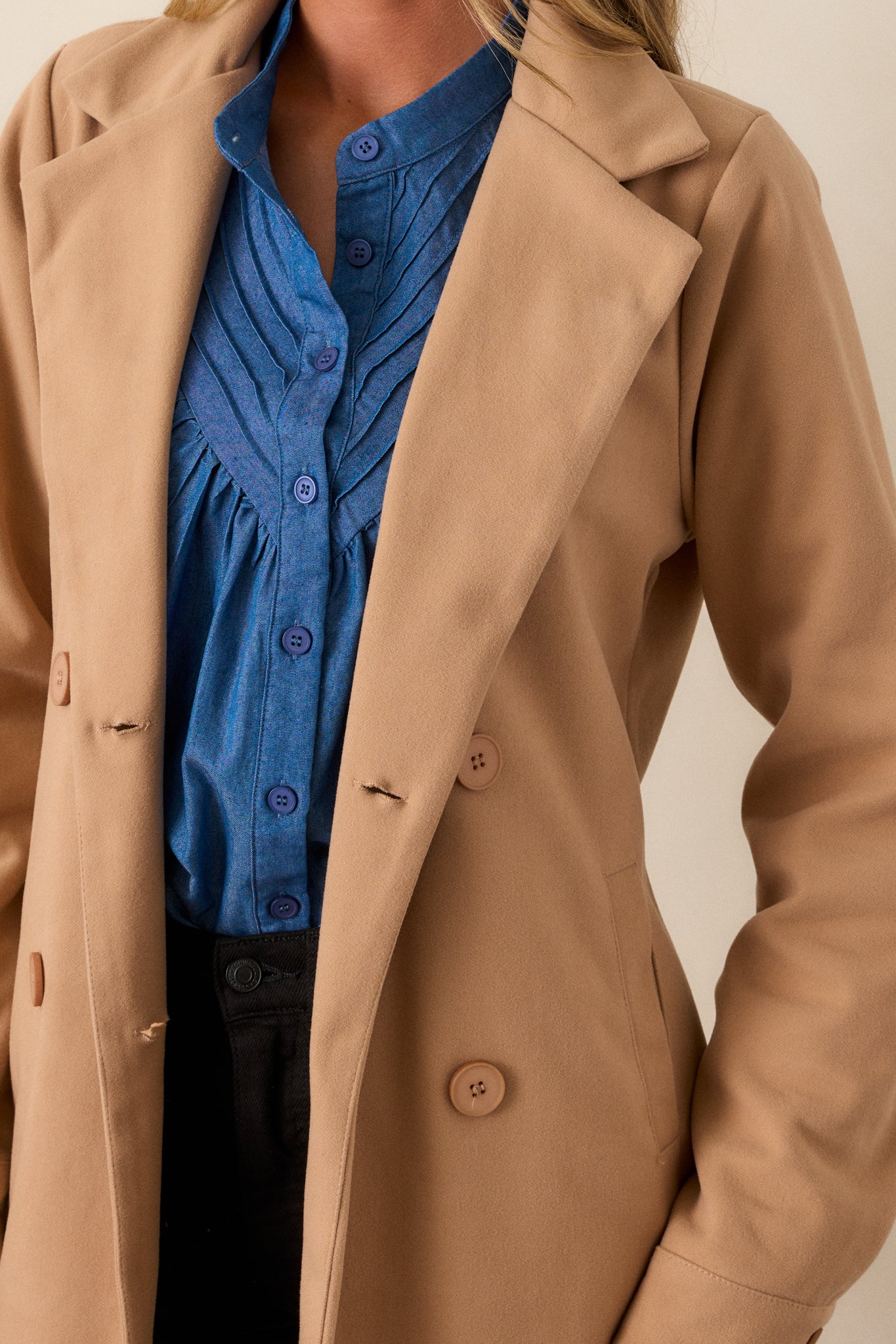 A detailed shot of the double-breasted button front, highlighting the notched lapels and the sleek, polished buttons.