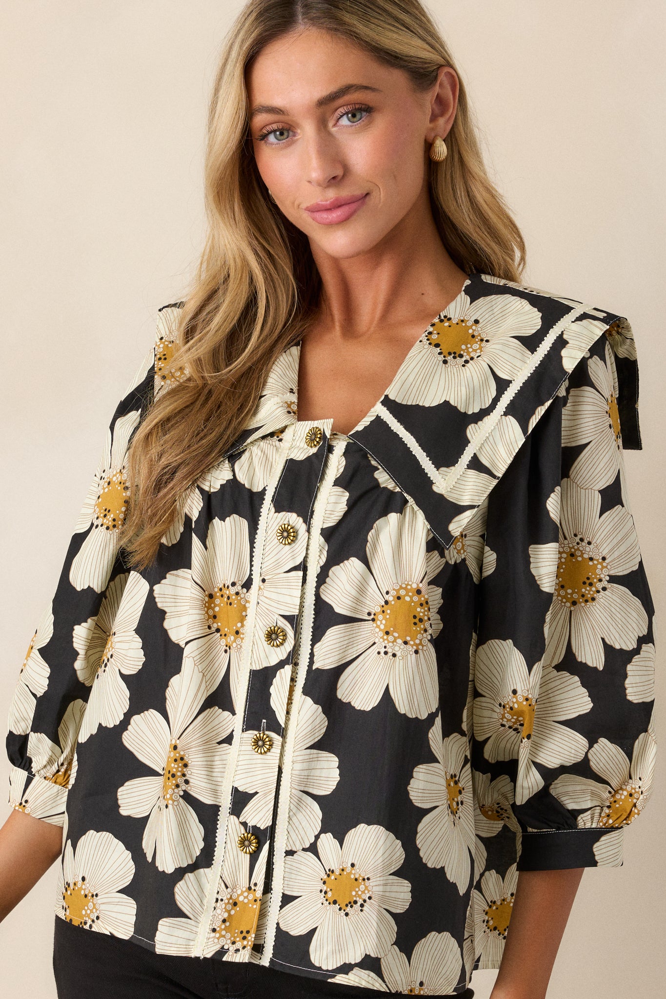 An angled view showcasing the ivory floral print and the trim detailing on the sleeves and neckline.