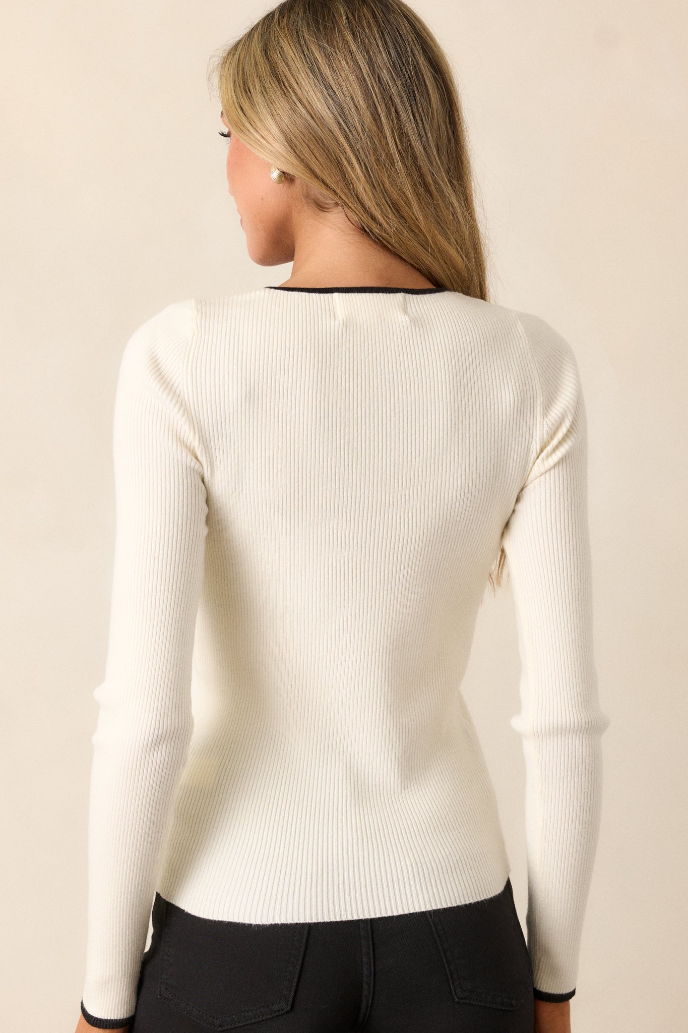 Back view of the ivory top displaying the long sleeves and scoop neckline, with a smooth finish that maintains the elegant look.