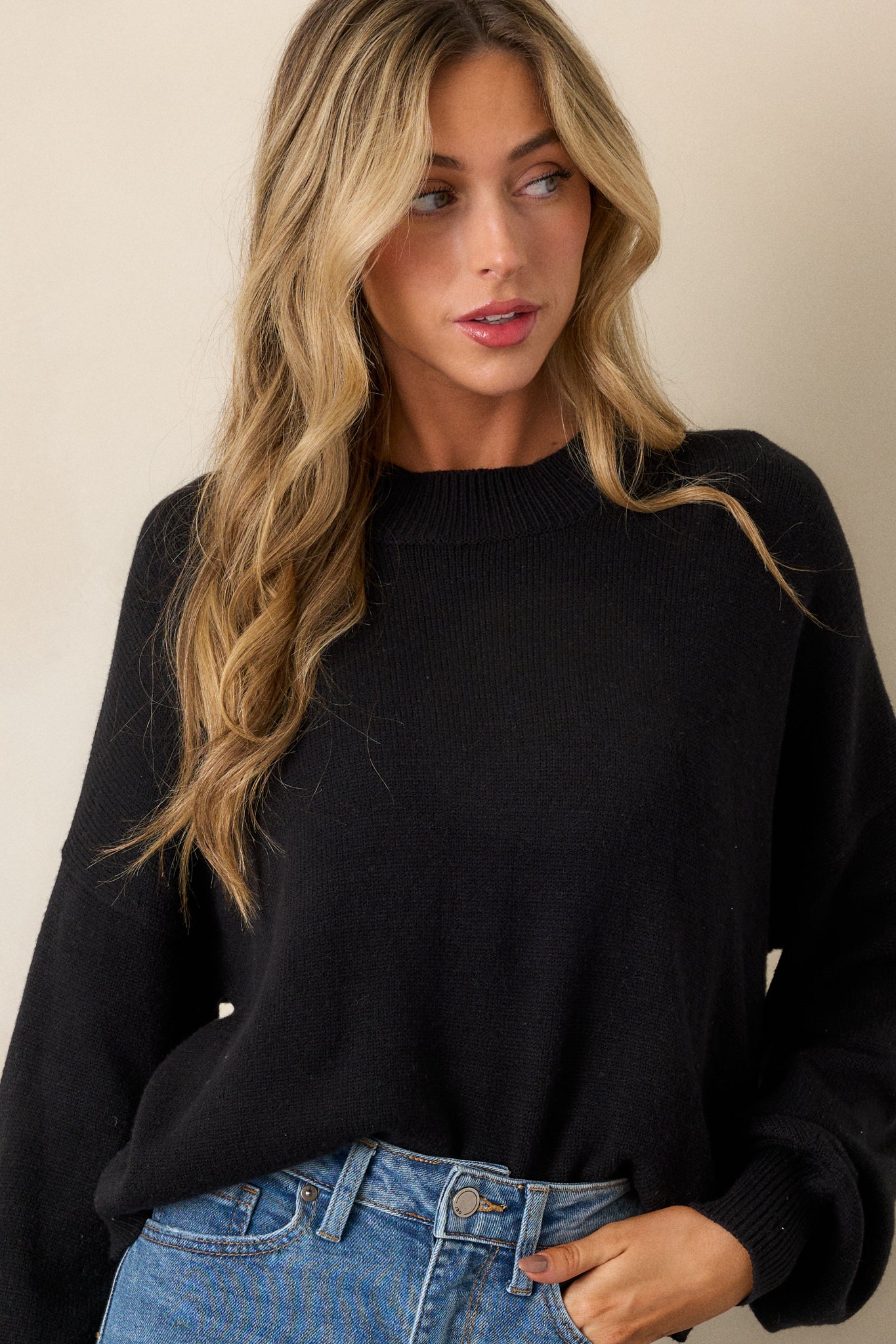 A cropped view focusing on the lower half of the sweater, highlighting the way the bottom hem gently tapers in for a more fitted look.