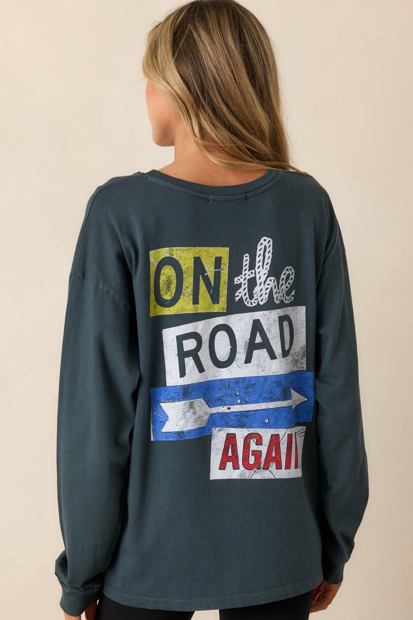 A back view of the charcoal tee, showing the relaxed fit and long sleeves. The simple, plain back of the top is visible, contrasting with the bold graphic on the front.