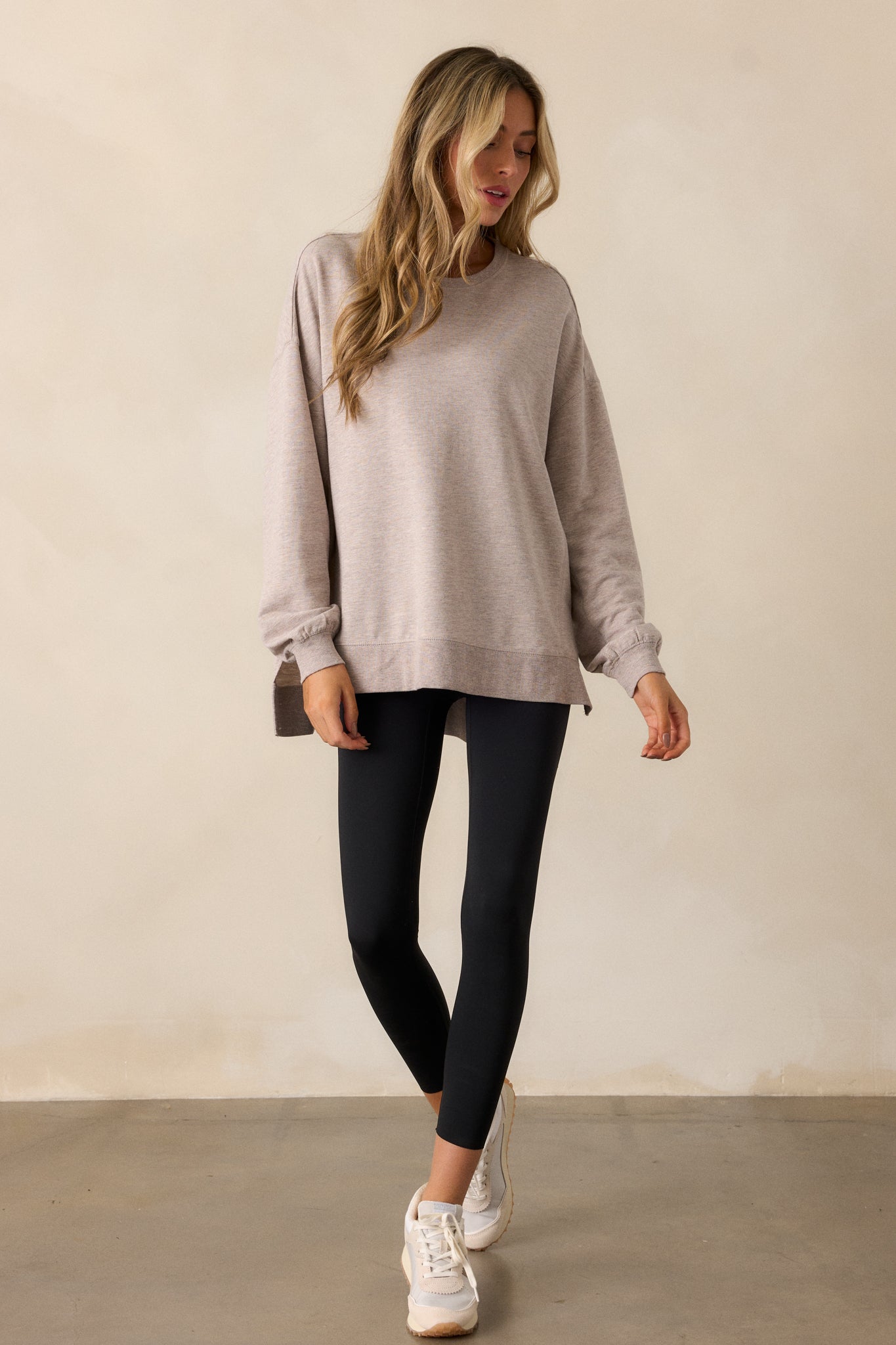 Full view of a taupe top with a crew neckline, oversized fit, drop shoulders, and a high-low split hemline.