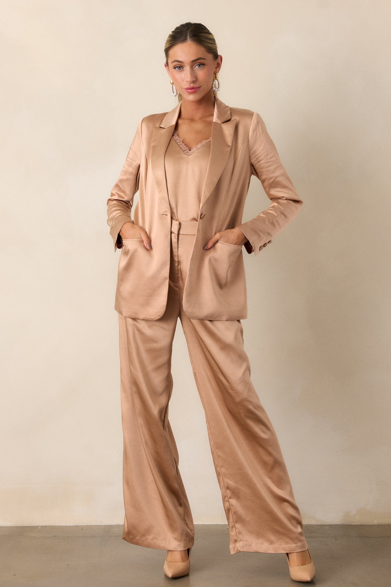 The trousers displayed with a front-facing view, highlighting the hidden front zipper, hook and eye closure, and the sleek drape of the satin material.