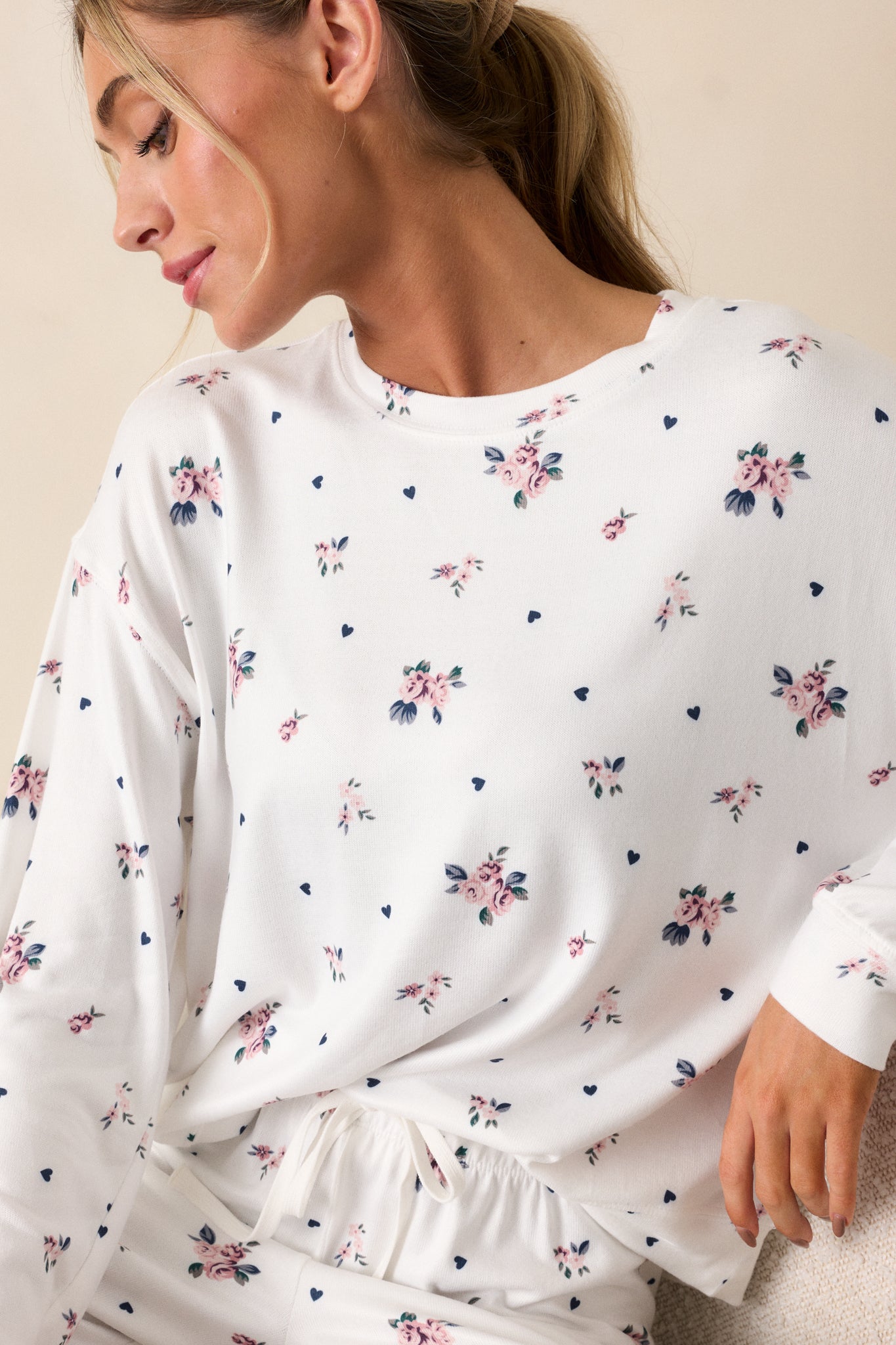 A cropped-in shot highlighting the relaxed fit and crew neckline of the ivory top. The rosebud pattern is visible across the fabric, giving it a feminine touch.