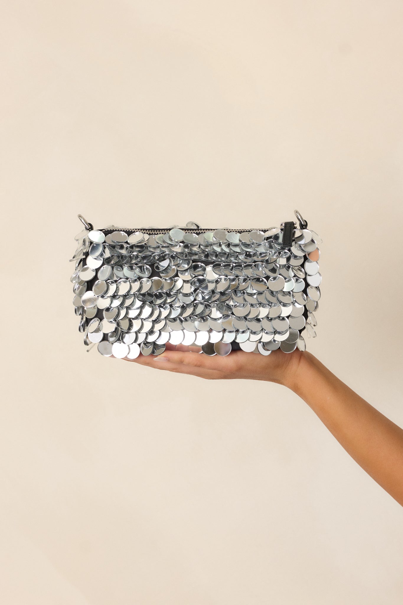 Focused shot of the silver clutch showing the arrangement of mirror discs glimmering under light.