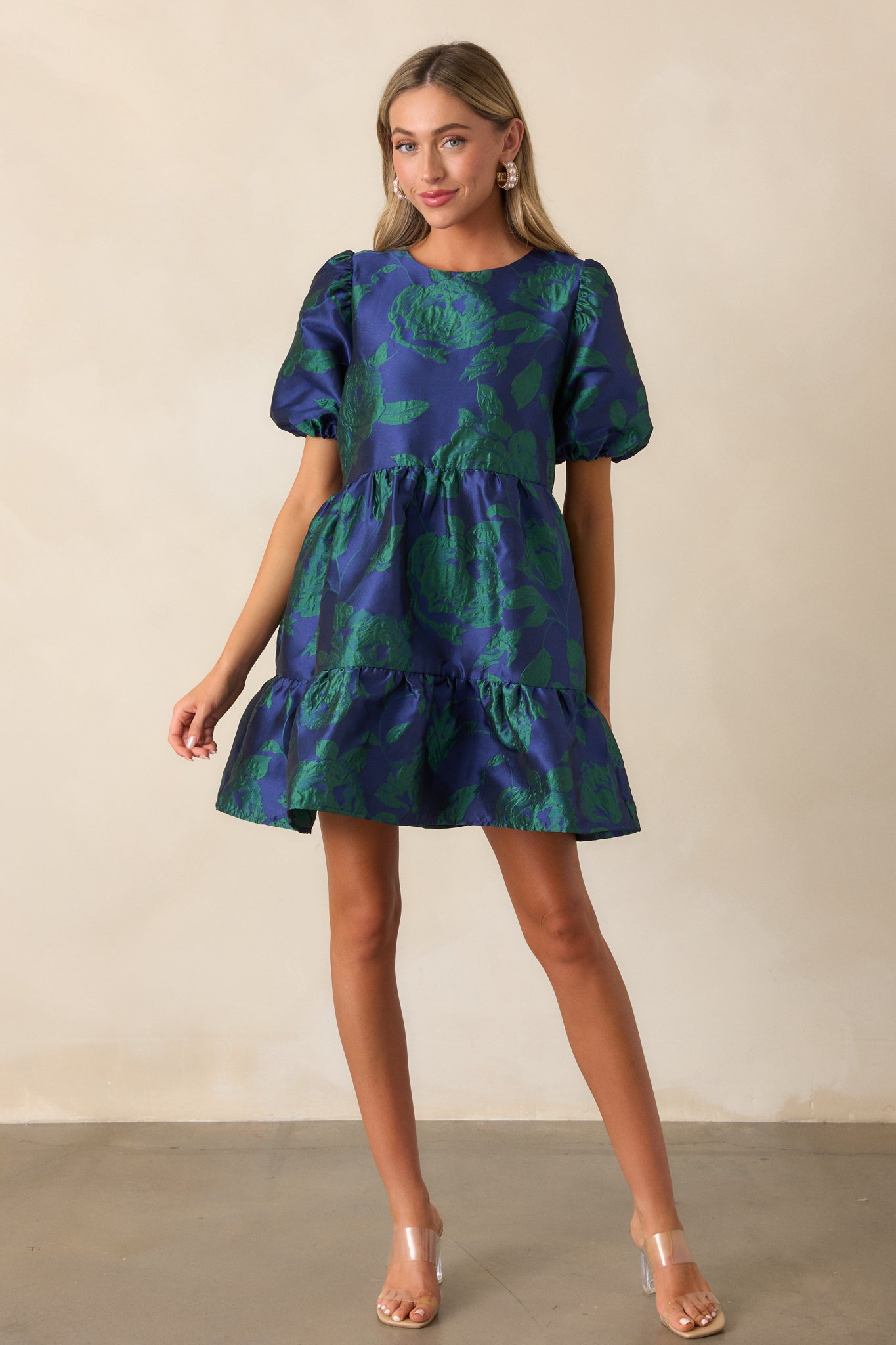 Full-length shot of the midnight blue mini dress with short puff sleeves, a round neckline, and a tiered skirt, emphasizing the textured jacquard fabric.