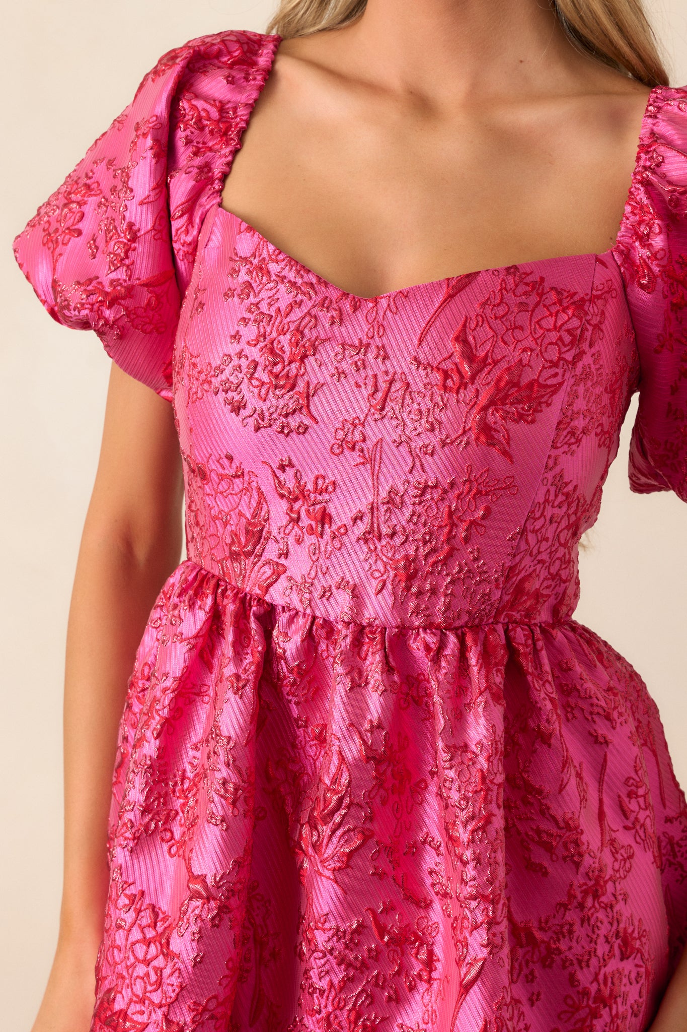 Close-up shot of the front of the dress, highlighting the sweetheart neckline and the red sparkle detailing along the bodice.