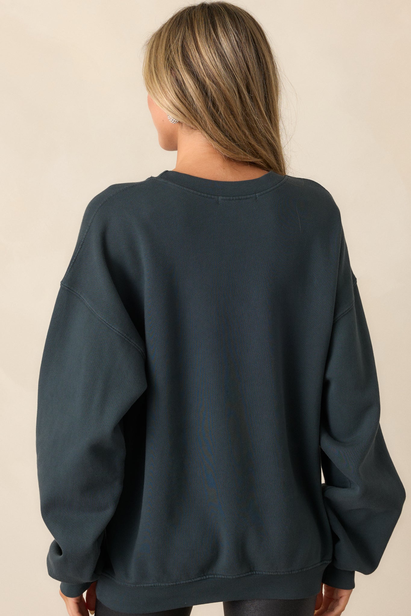 Back view of the charcoal sweatshirt, showcasing the long sleeves and simple, clean back design.