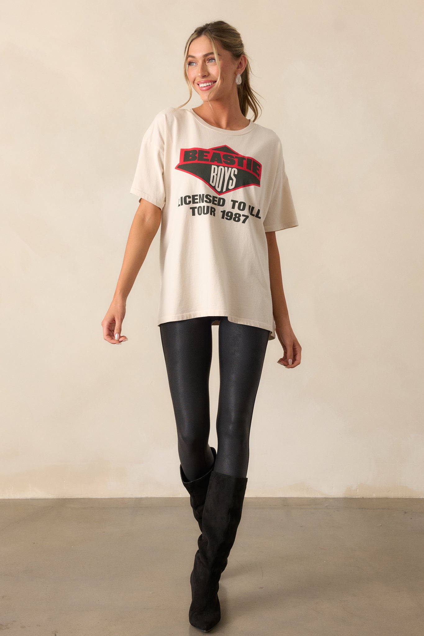 A relaxed ivory tee featuring a classic round neckline and short sleeves, with a vintage-style 'Beastie Boys 1987' graphic on the chest.