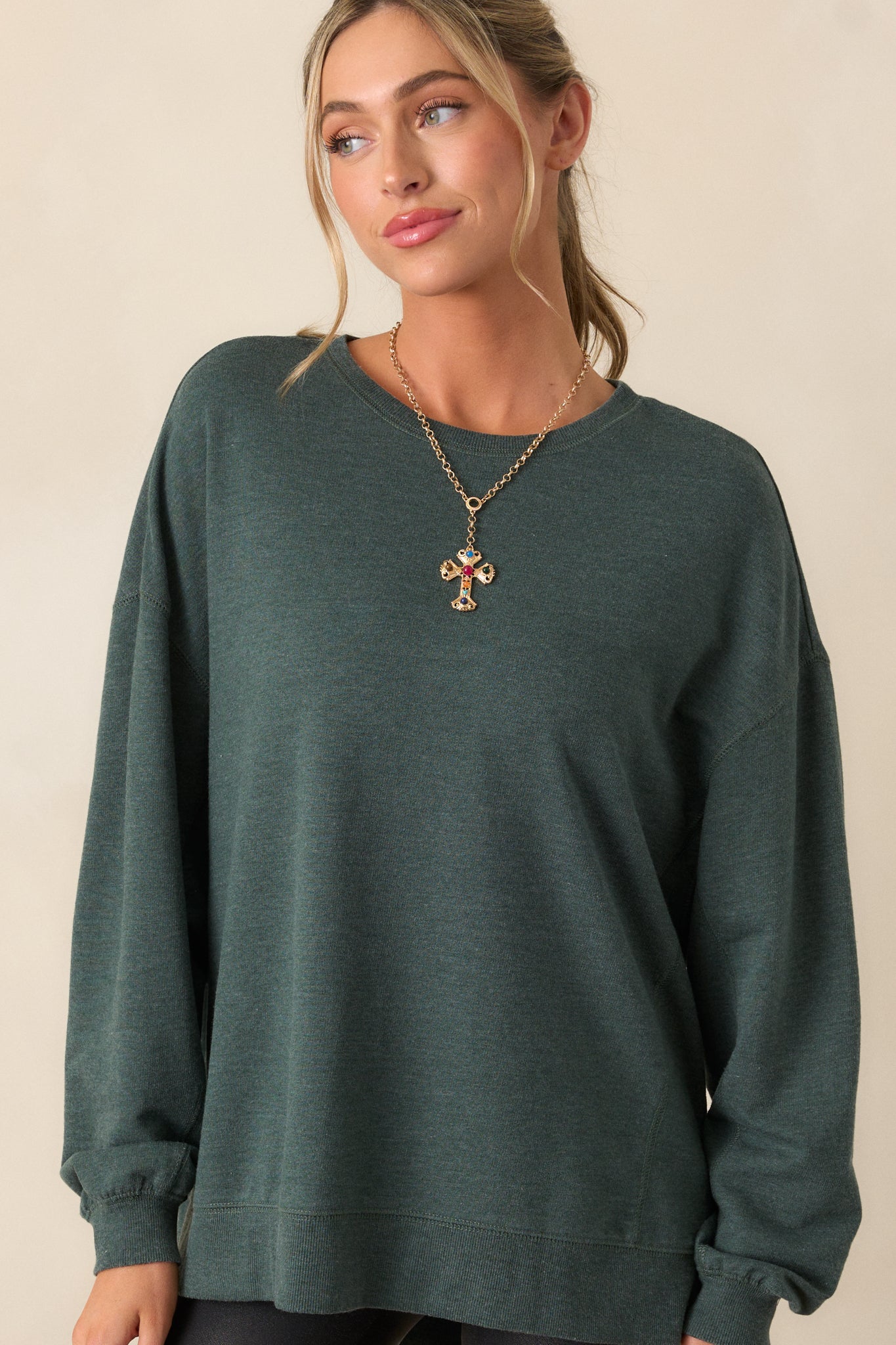 Front view of this top that features a crew neckline, dropped shoulders, ribbed cuffed sleeves, and a high-low split hemline.