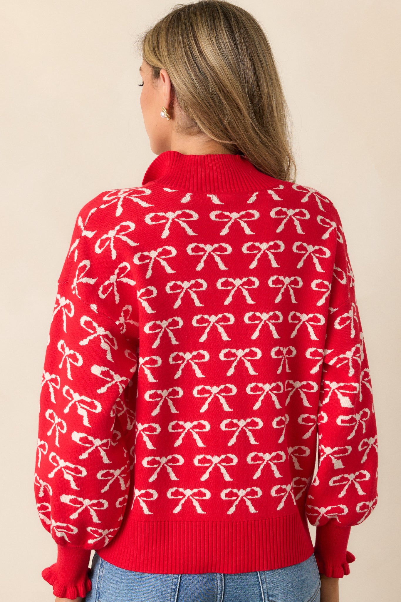 A back view of the pullover, with emphasis on the quarter zip collar and the soft texture of the red fabric, showing the print and fit of the garment.