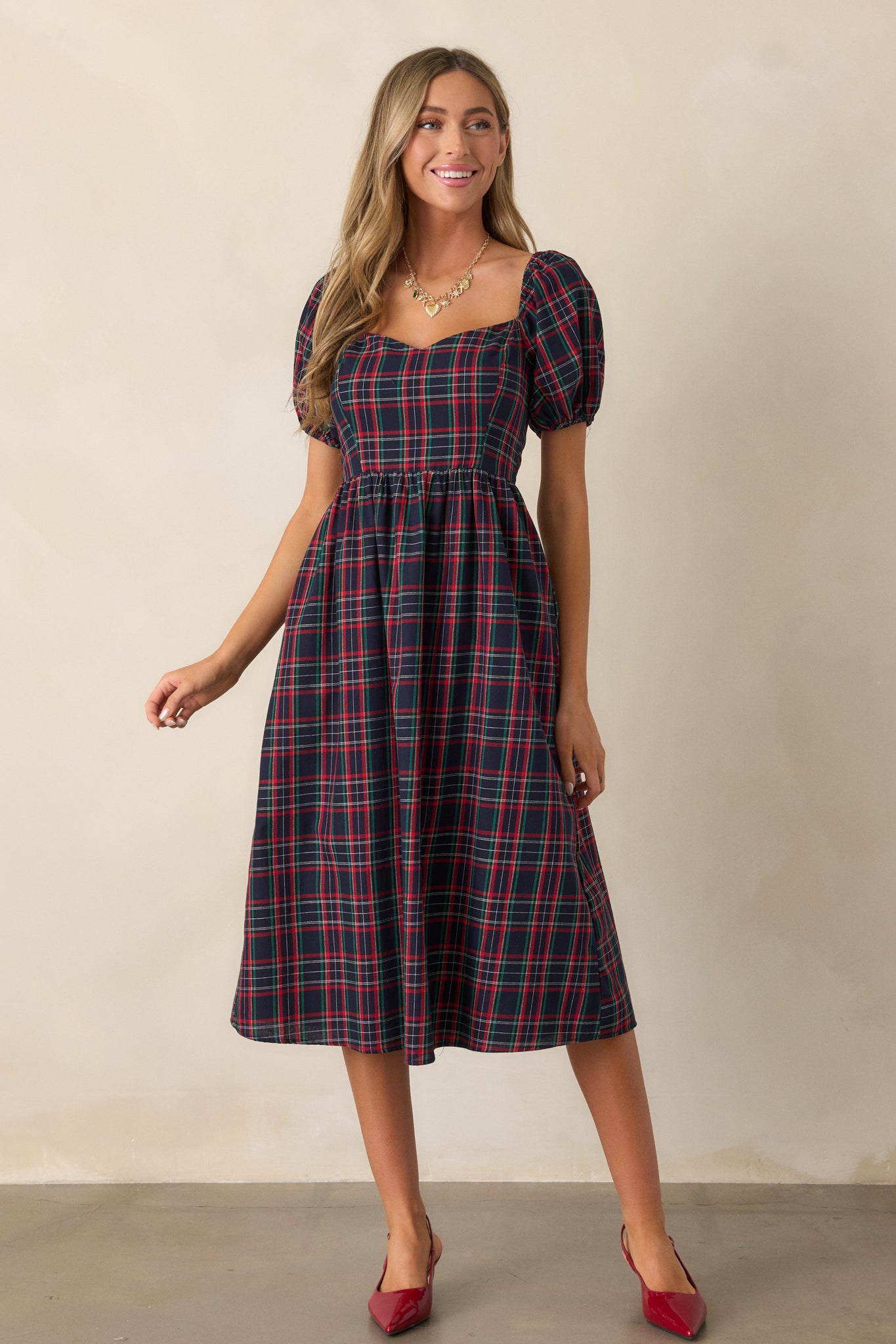 Front view of the navy dress highlighting the sweetheart neckline, plaid print, and short puff sleeves.