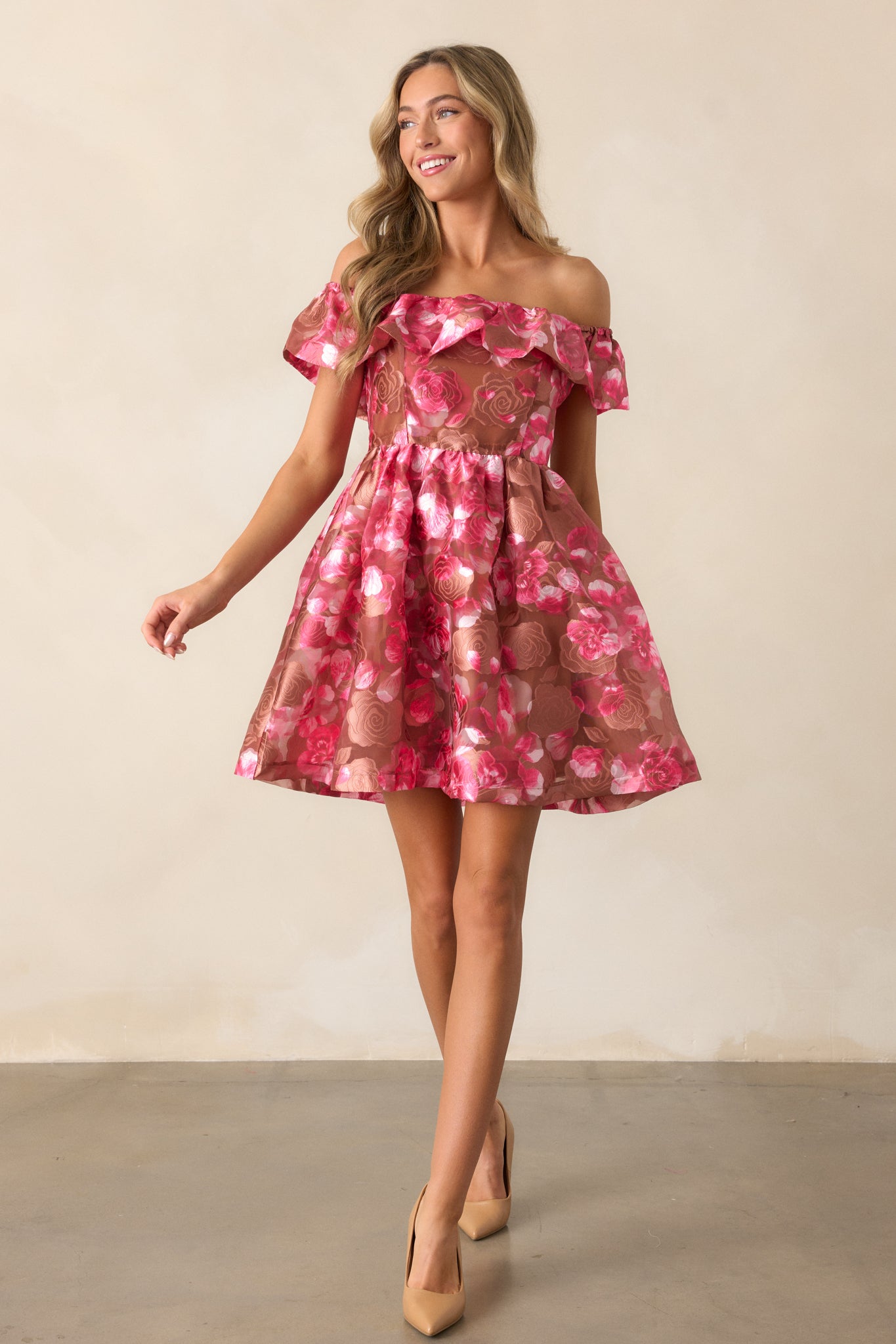 A mini dress with a camel-colored floral overlay, featuring an elastic off-the-shoulder neckline, babydoll silhouette, and ruffled hem.