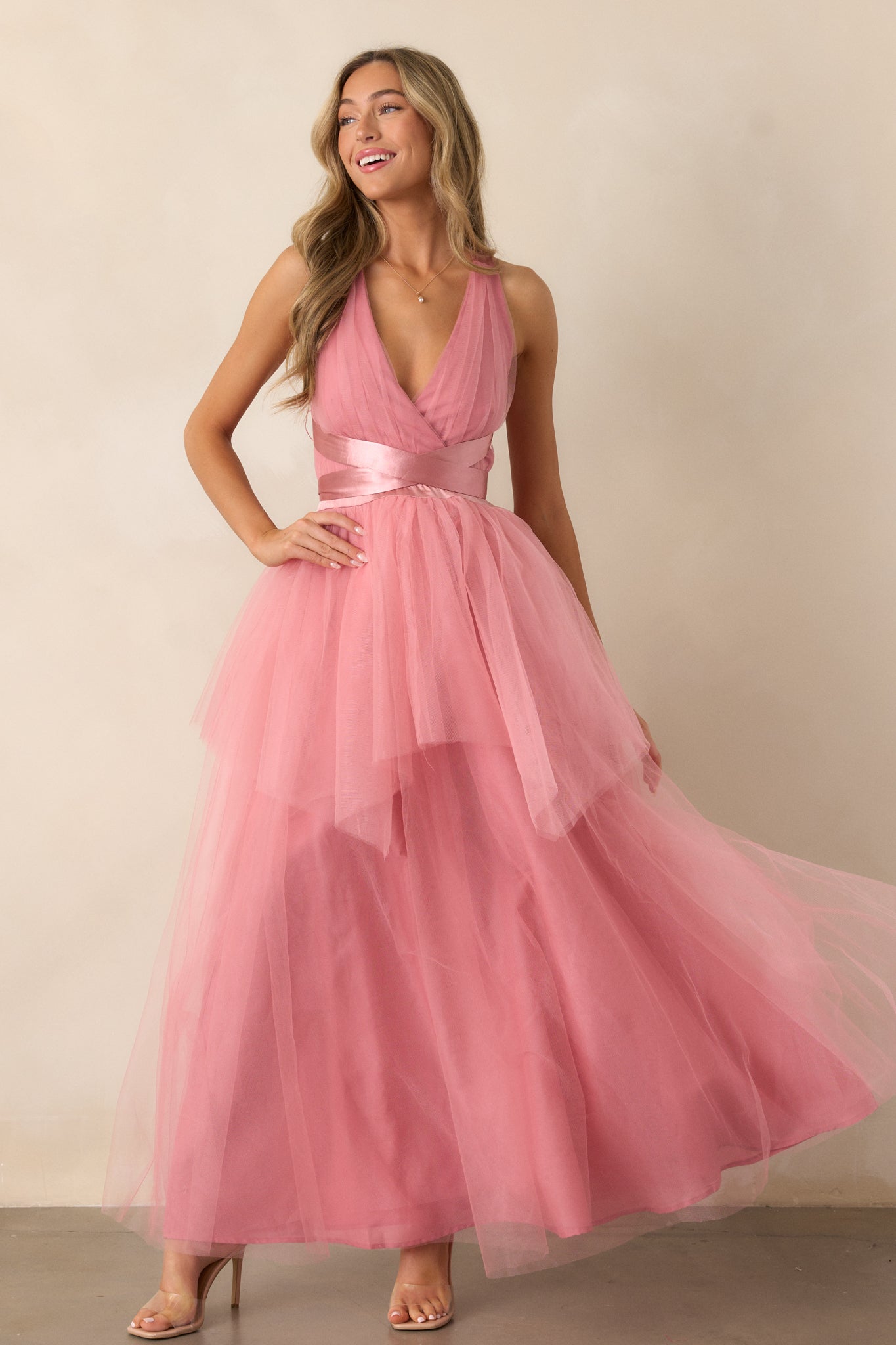 Front view of the dress featuring a deep V-neckline, self-tie straps that cinch at the waist, and a textured, layered skirt that adds volume and movement.