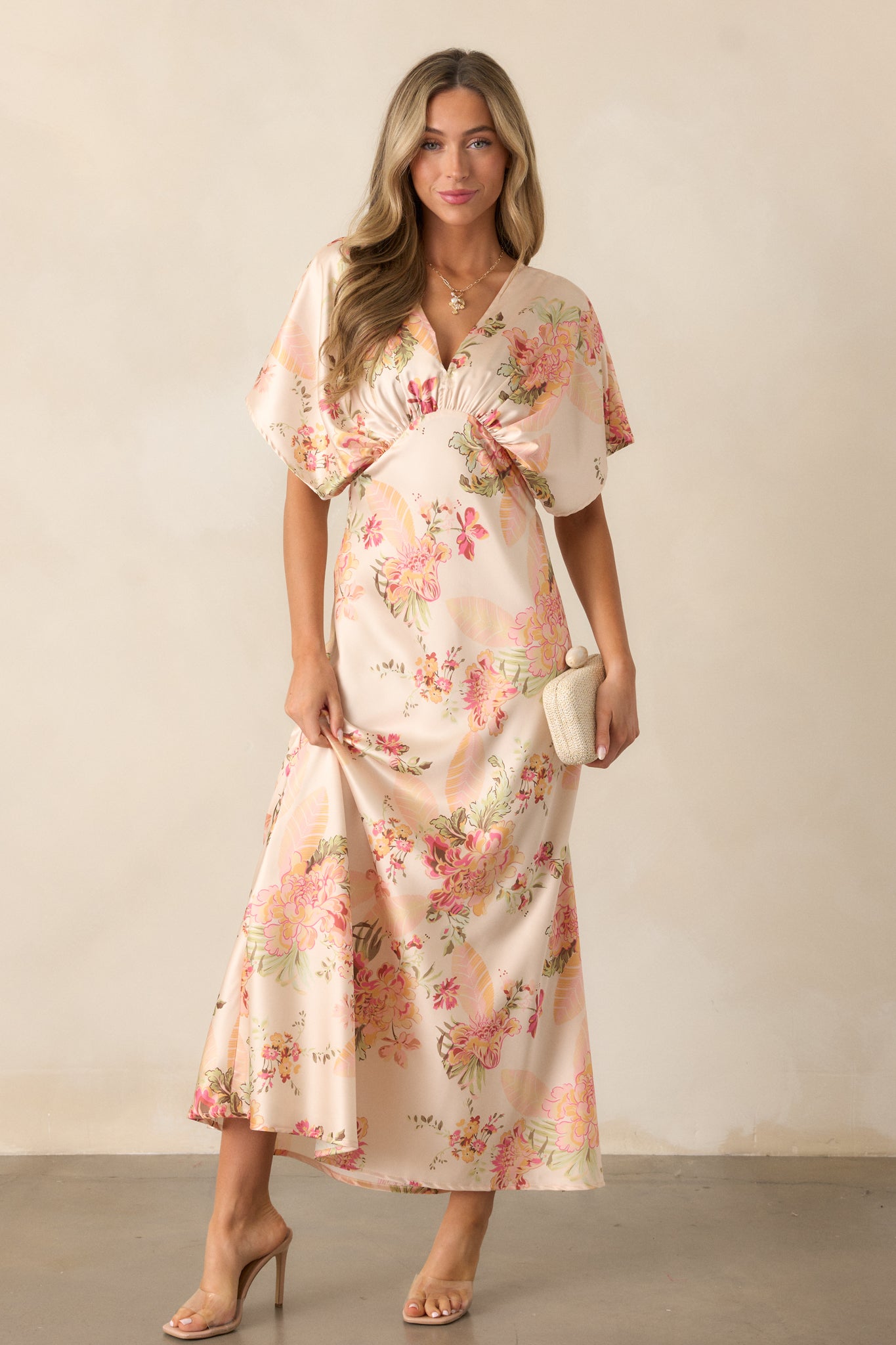 A full-length view of the dress with a V-neckline and a fitted empire waistline, flowing into wide sleeves and a side slit.