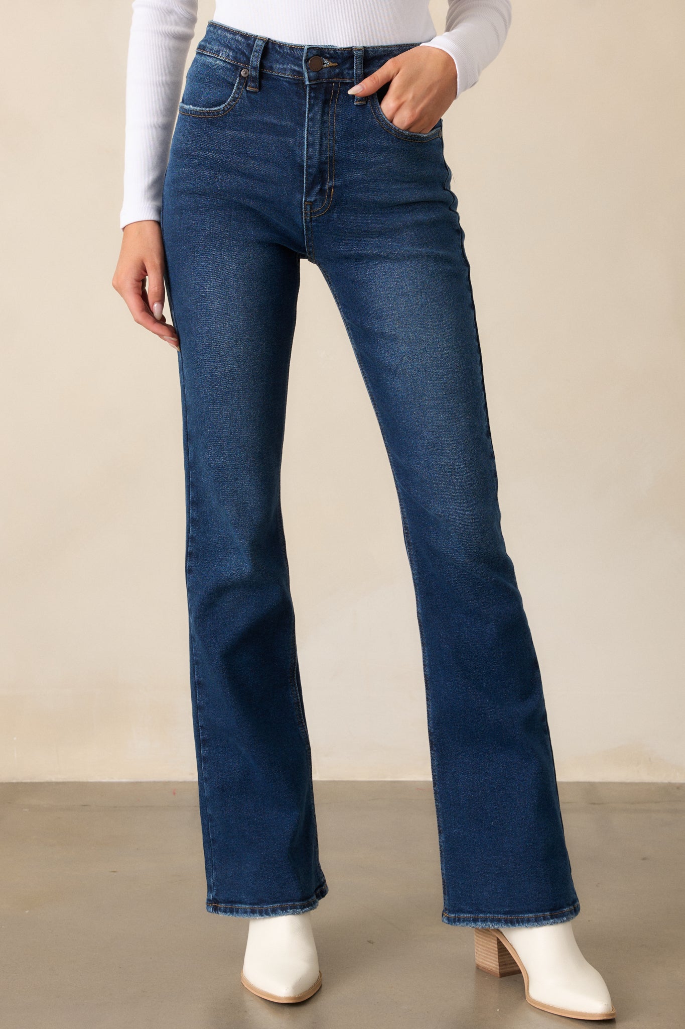 A close-up of the jeans emphasizing the zipper and button closure, belt loops, and front pocket stitching.