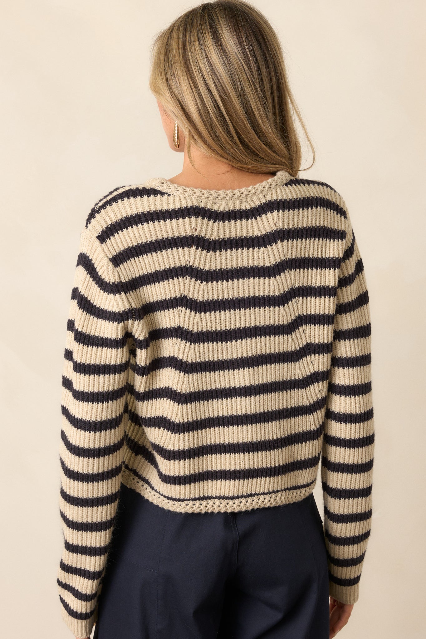 A back view of the tan cardigan, showing the simple yet stylish design with black and tan stripes. The long sleeves complete the cozy look, while the back highlights the cardigan’s overall relaxed fit.