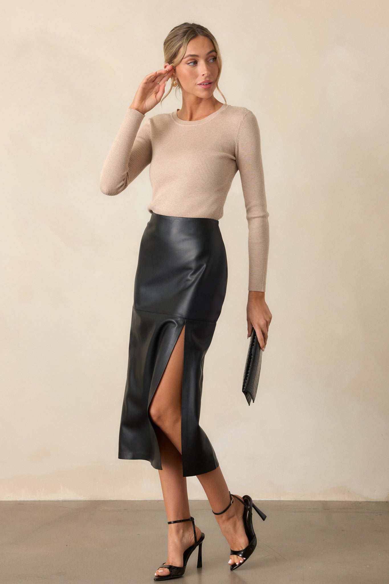 Side view of a model wearing the tan top, featuring a ribbed crew neck and stretchy ribbed fabric that hugs the body in a streamlined silhouette