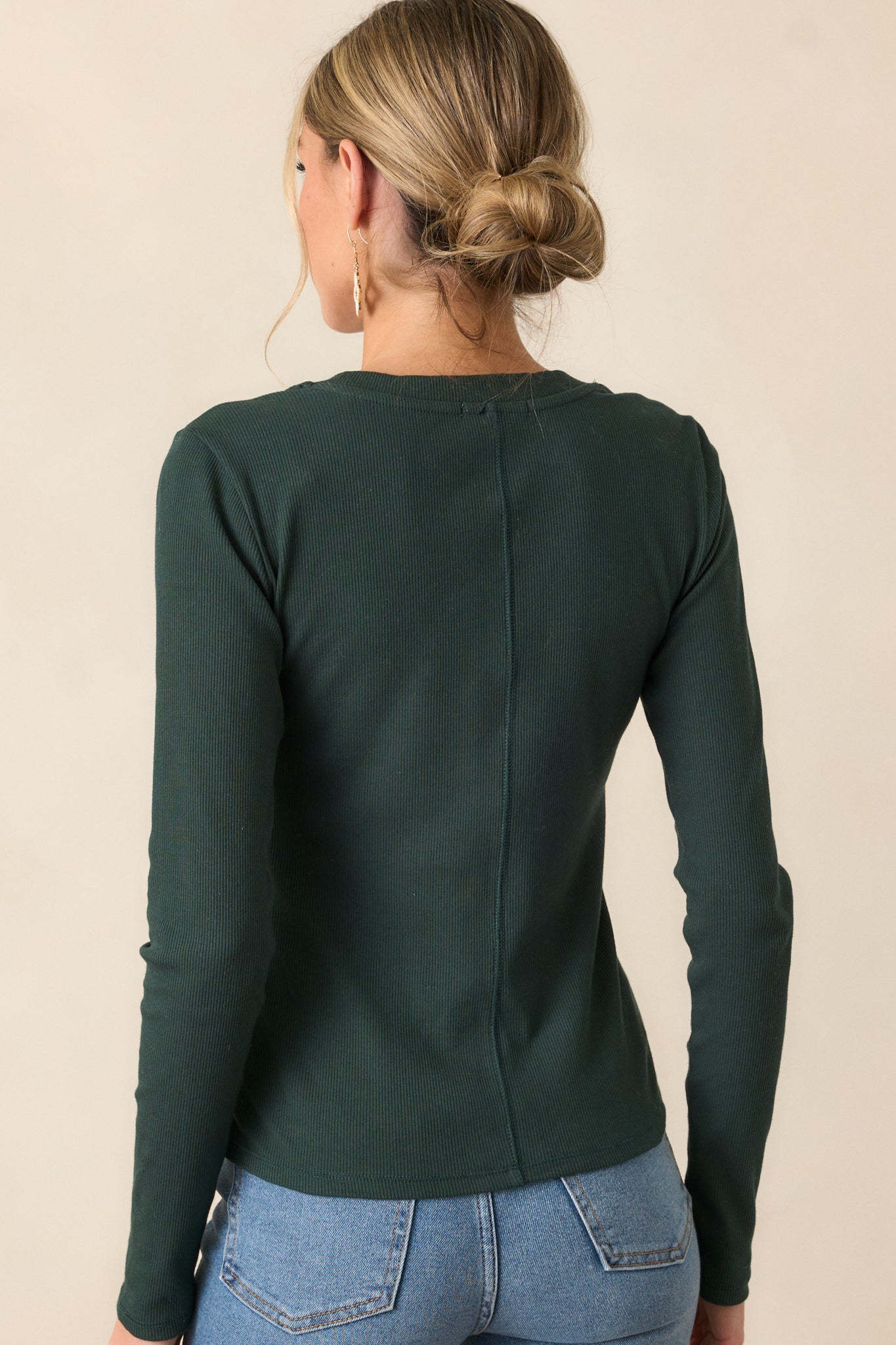 Back view of a green top highlighting the ribbed detailing and long sleeves.