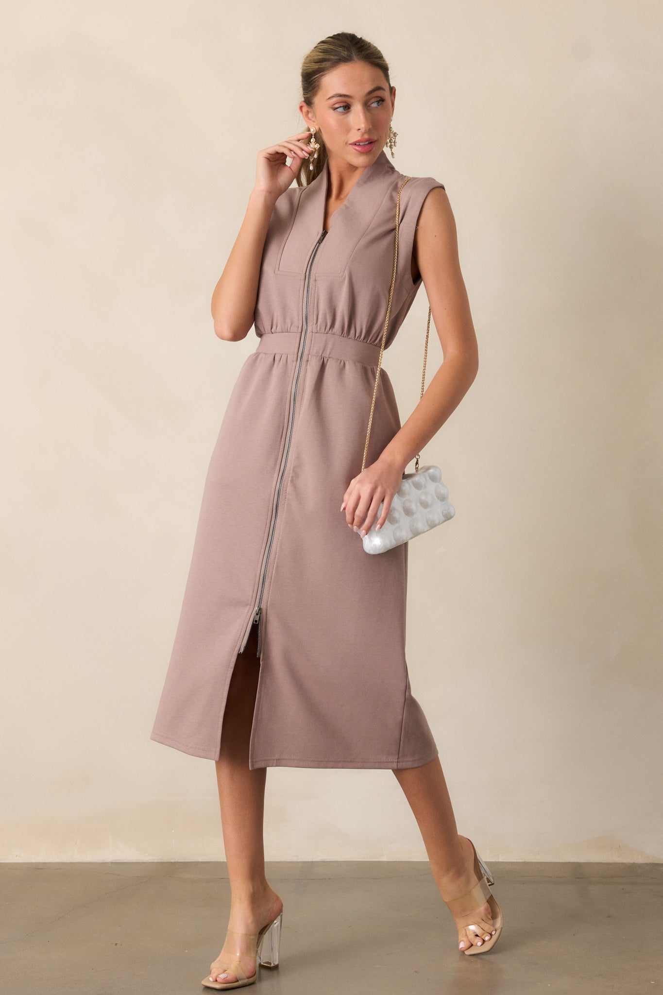 A full-body view of a dress featuring an elastic waistband that cinches at the waist, creating a flattering silhouette.  The dress also showcases a V neckline with a slight collar, adding a touch of sophistication to the overall design