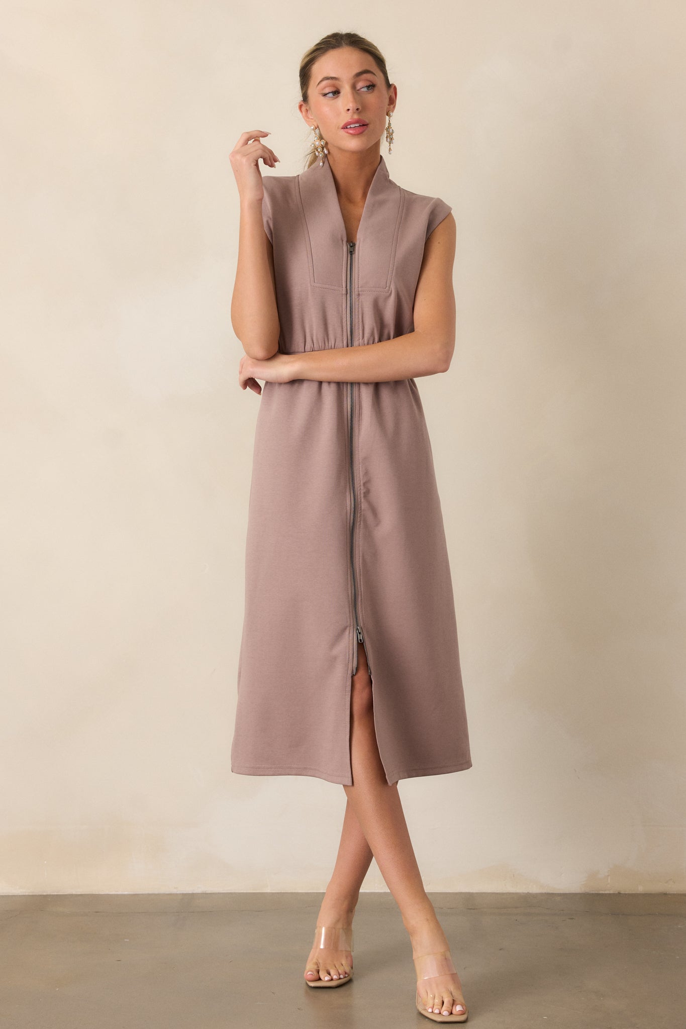 A full-body view of a dress in a dark taupe color, featuring a front zip that adds both style and functionality. The fabric flows smoothly, creating an elegant and relaxed silhouette that moves gracefully.