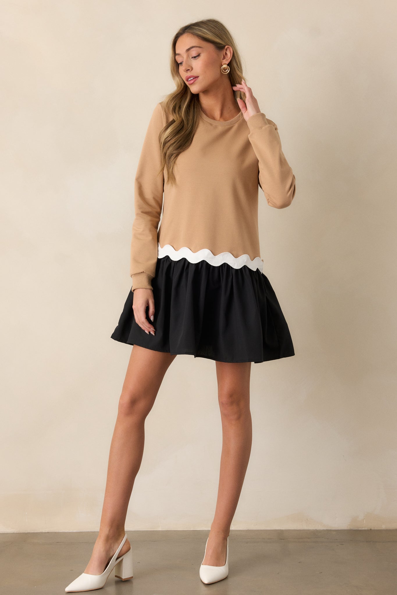 Front view of the mini dress, showcasing the tan and black colorblock design, crew neckline, and drop-waist silhouette.