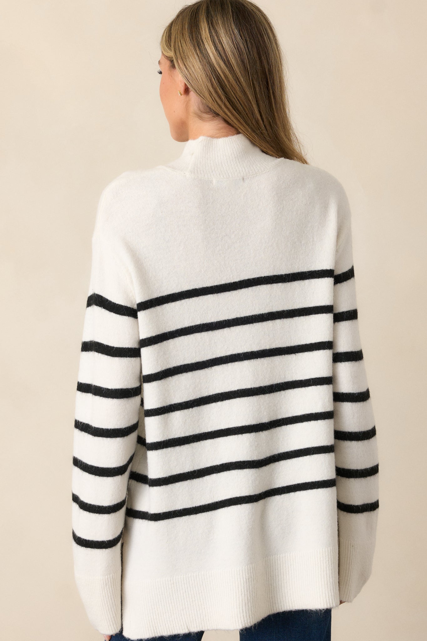 Rear view of the ivory sweater, featuring a clean, seamless back design and relaxed fit.