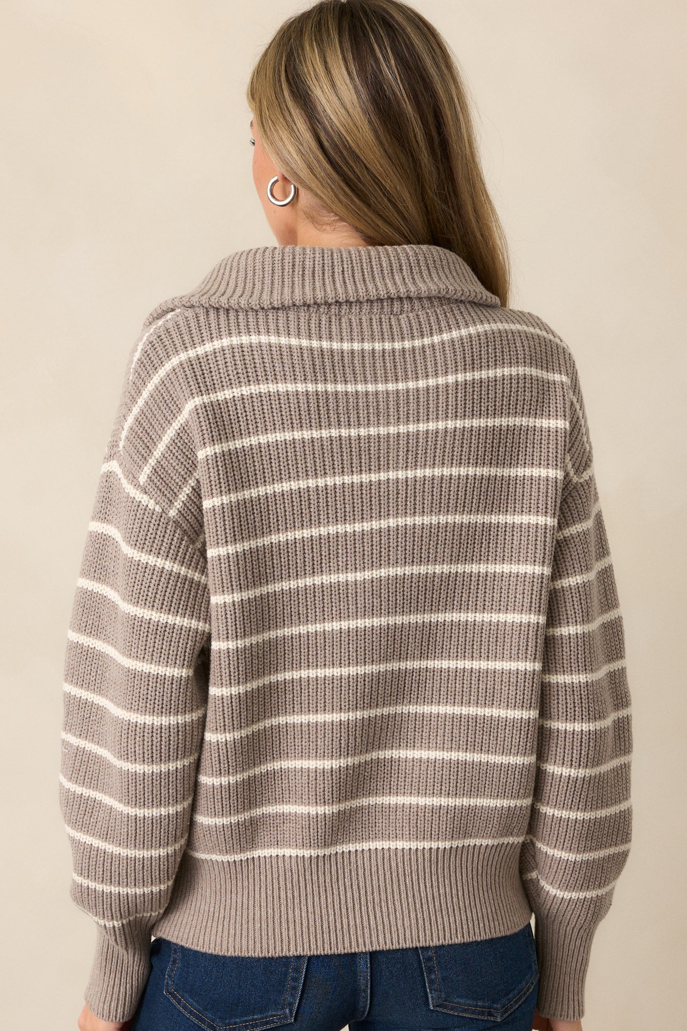 A back view of the heather taupe sweater, showing the oversized collar neckline and the smooth texture of the fabric. The rib knit hems are visible along the sleeves and bottom edge, completing the cozy, stylish design.