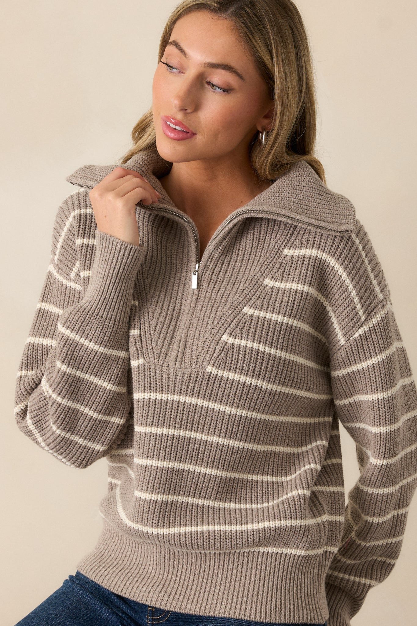 A cropped image highlighting the long sleeves and rib knit hems of the heather taupe sweater. The oversized collar and ivory stripe pattern create a chic, contemporary look.