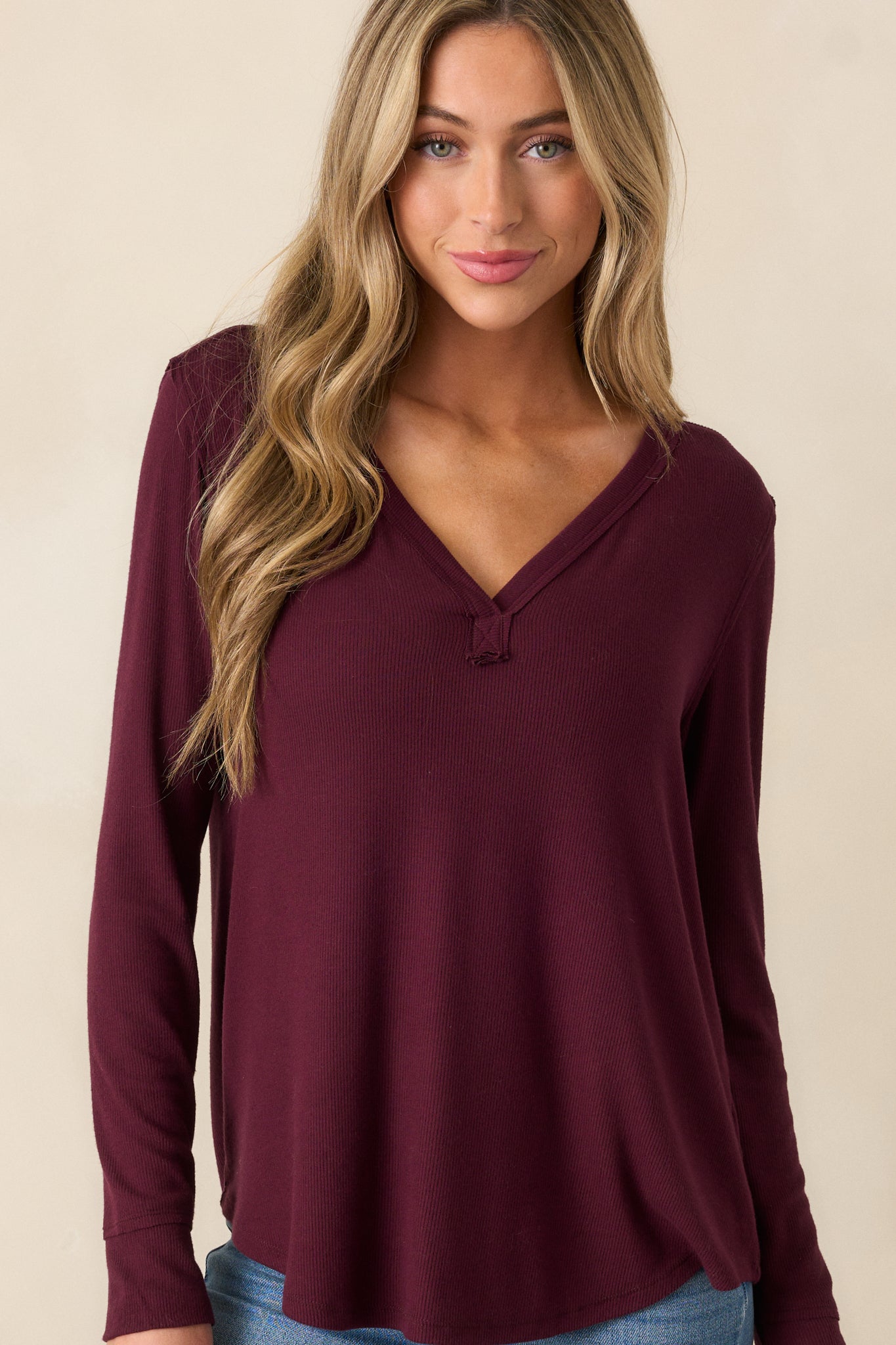 Close-up of the V-neckline on the berry top, emphasizing the ribbed texture and clean stitching around the neckline.