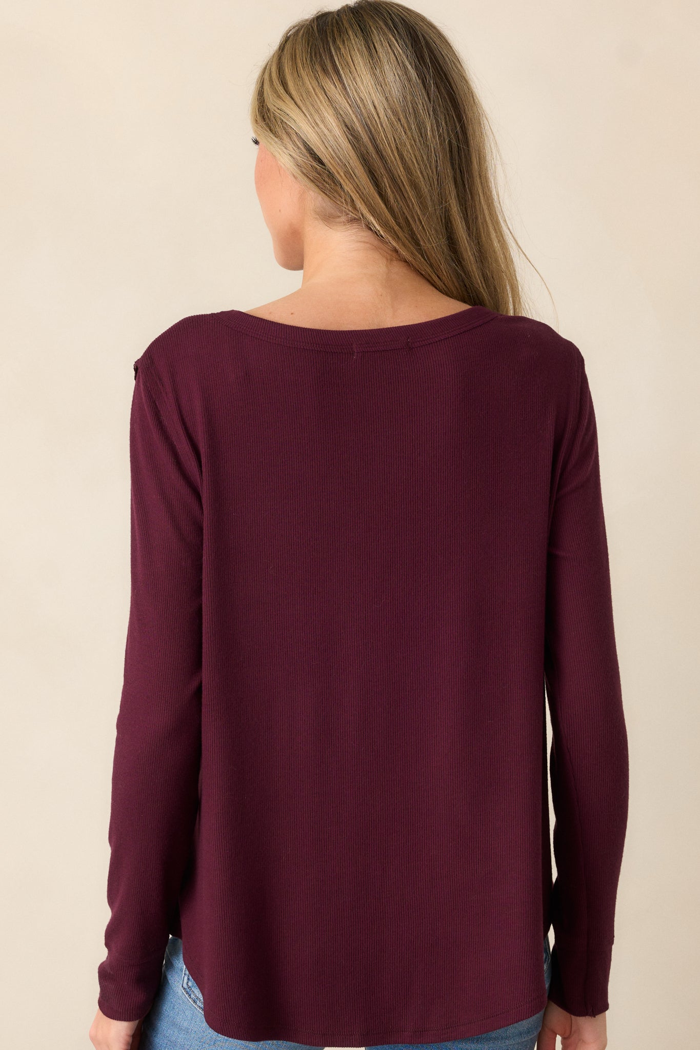 Back view of the berry top, highlighting the soft ribbed texture, long sleeves, and curved bottom hem that create a flattering fit.