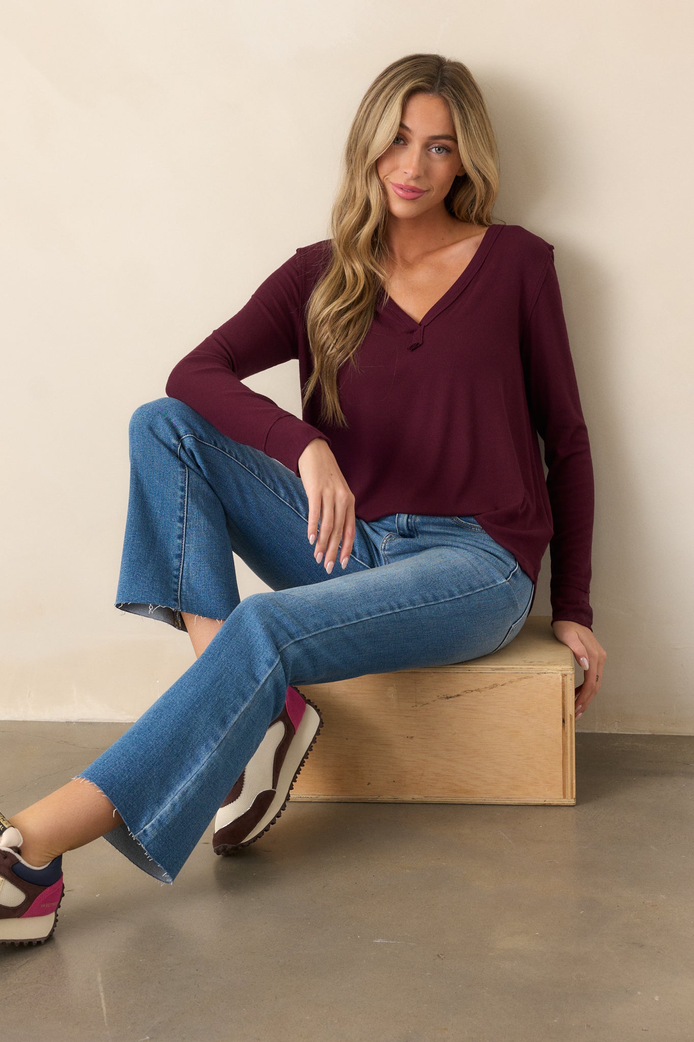 Front view of a berry top with a V-neckline and long sleeves, showing the ribbed design and the curved bottom hem.