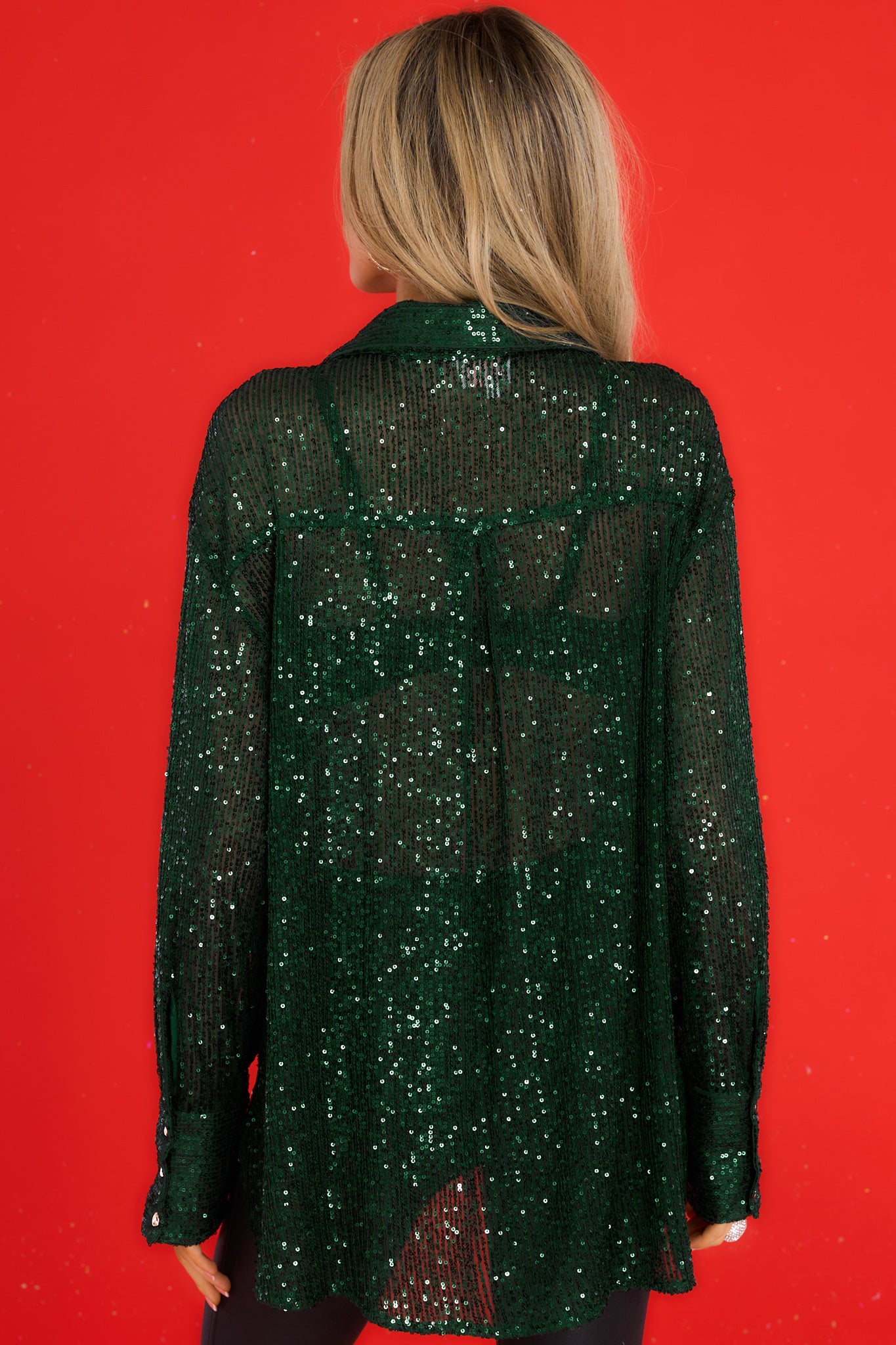 Back view of this top that features a collared neckline, functional buttons down the front, functional buttons at the cuffs, and sequins all throughout.