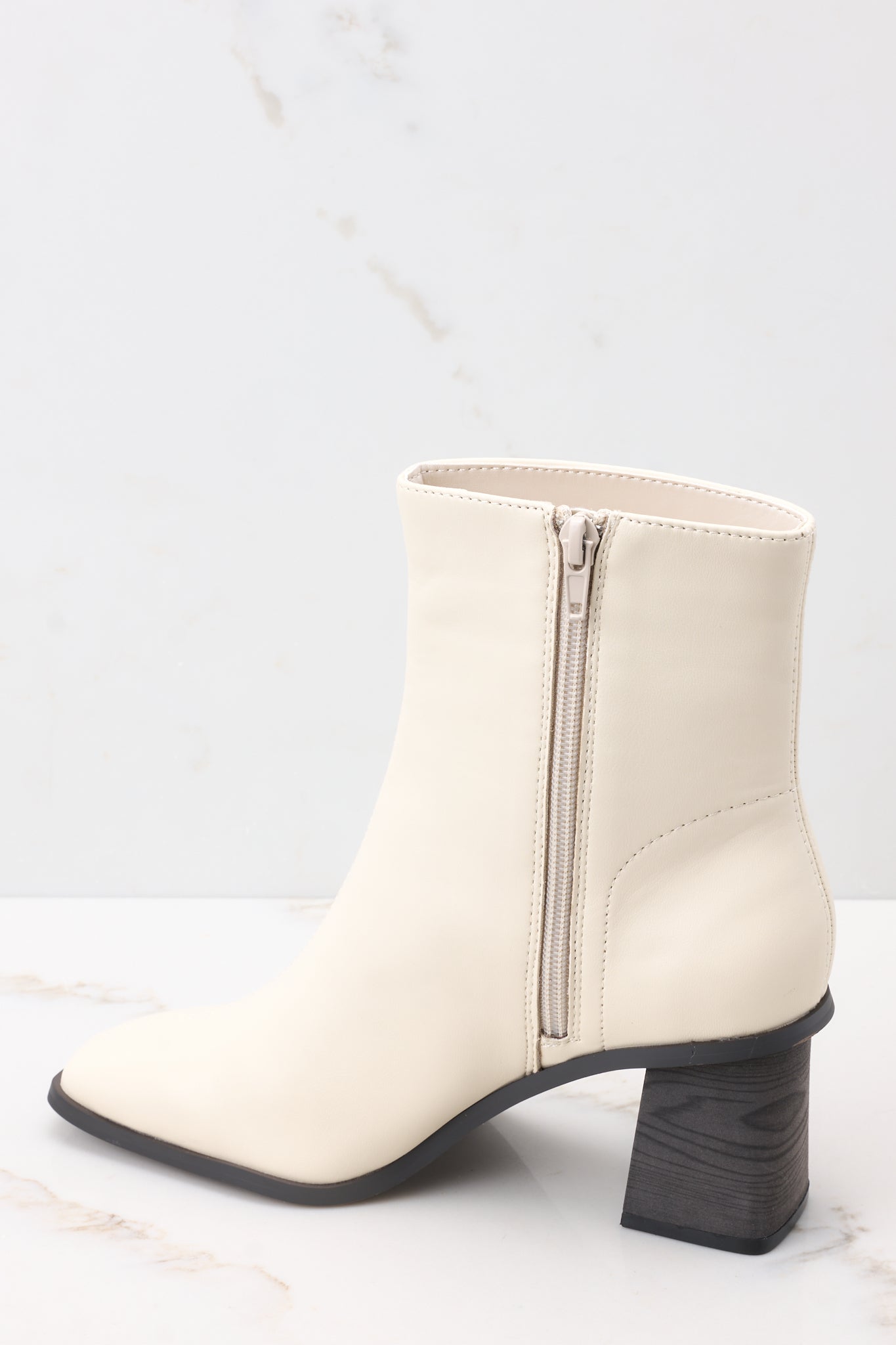 Inside view of beige high heel booties with a full inside zipper. 