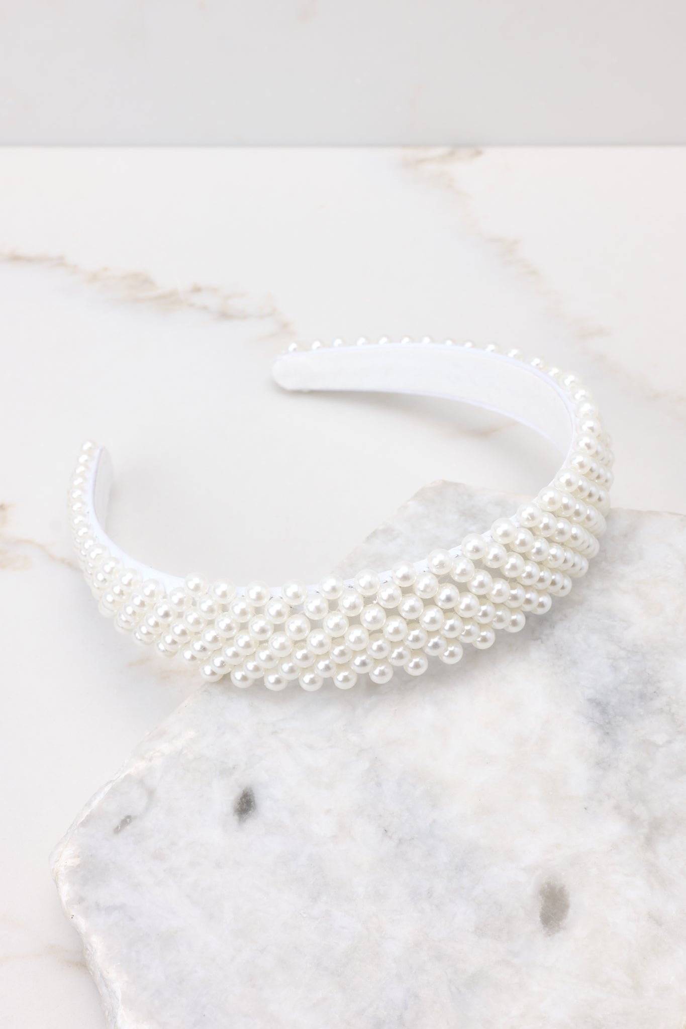 Top view of this headband that features a flexible design with pearl embellishments throughout.