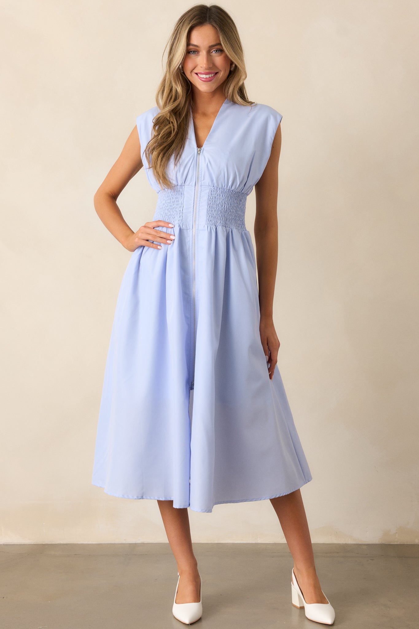 This baby blue midi dress offers a full zipper front, functional hip pockets, and a fully smocked waist for a comfortable, chic fit.